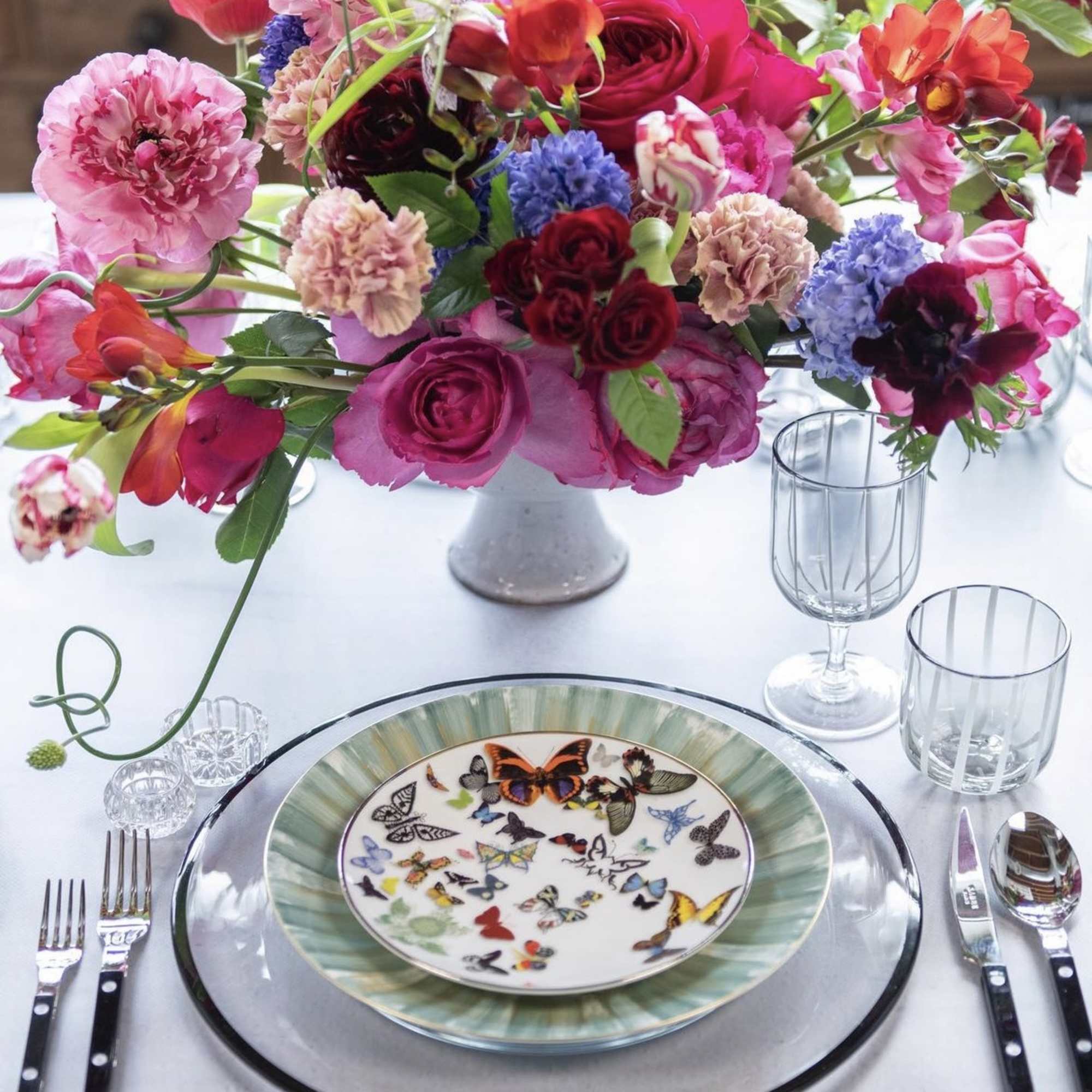 Colorful floral centerpiece in a low vase on a set dining table