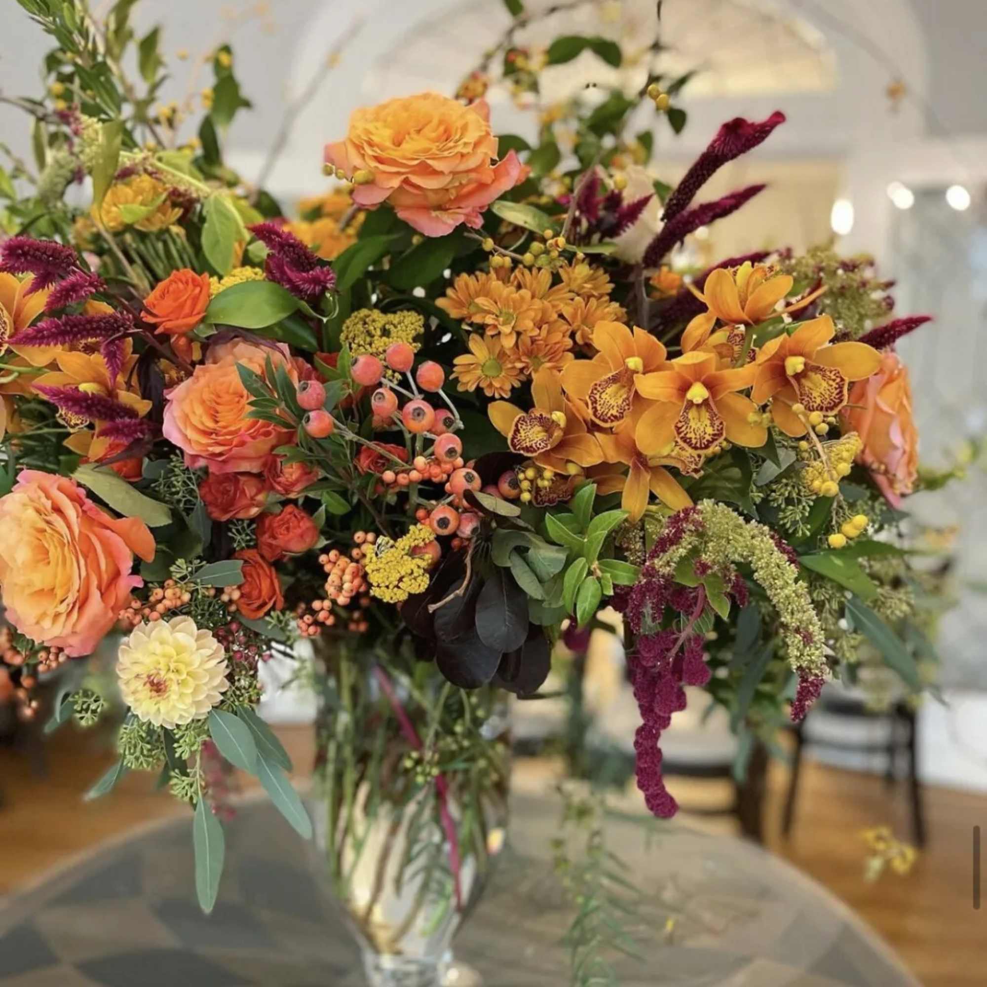 Orange and magenta floral arrangement in a clear glass vase