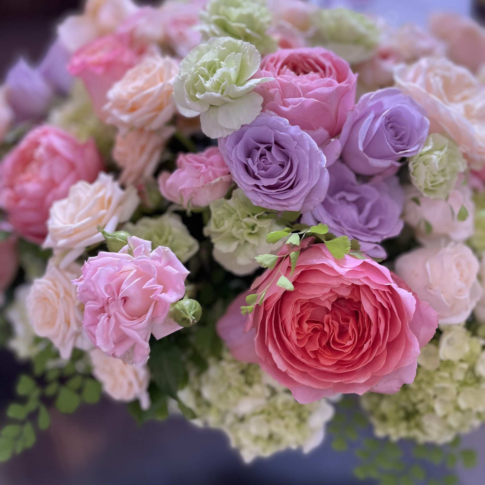 Bouquet of pink, lavender, and cream roses with pale green blooms