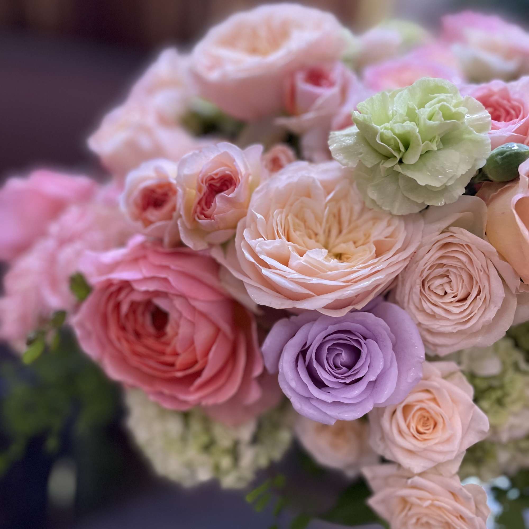 Bouquet of pastel roses and ranunculus in pink, peach, and lavender