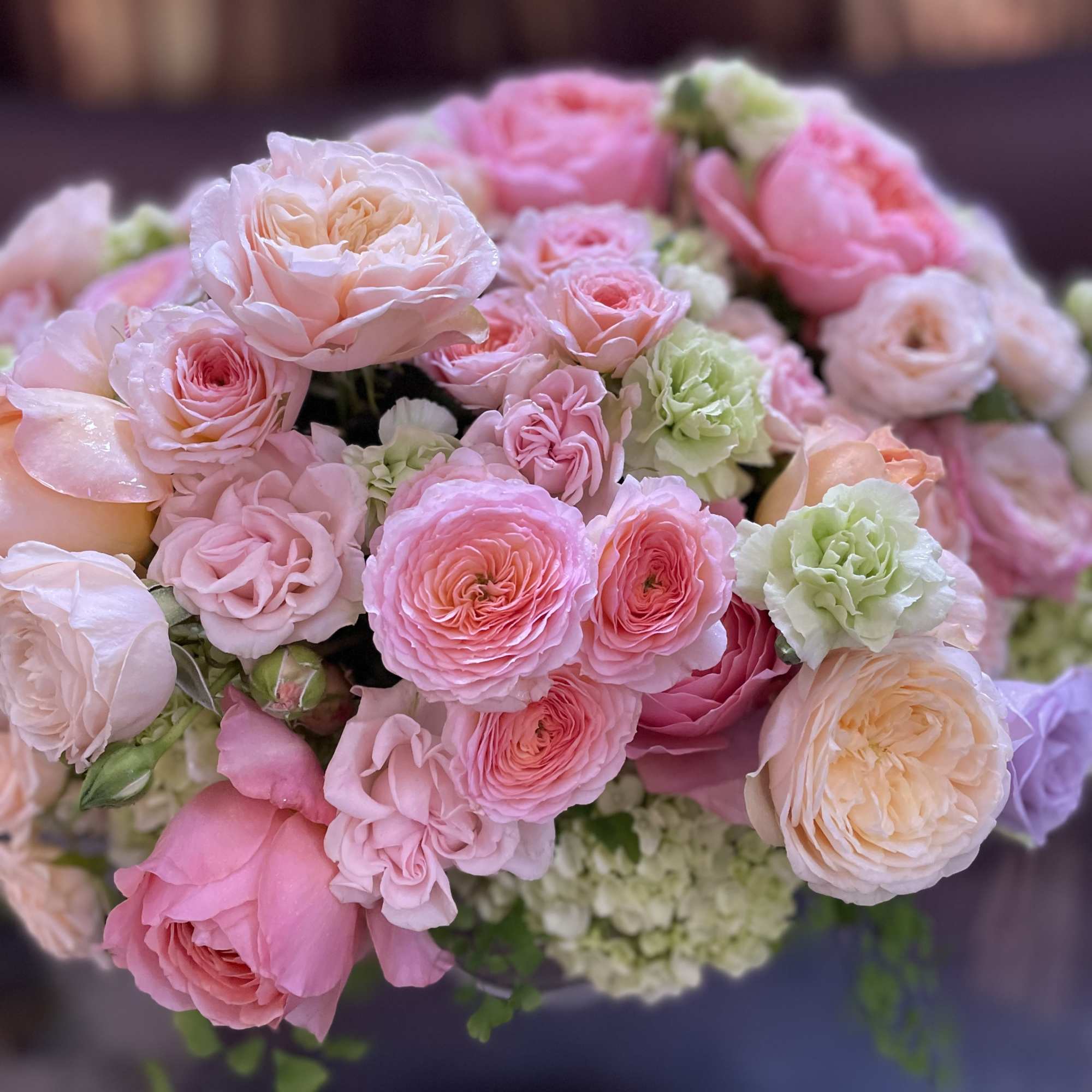 Bouquet of pink and peach roses with pale green blooms