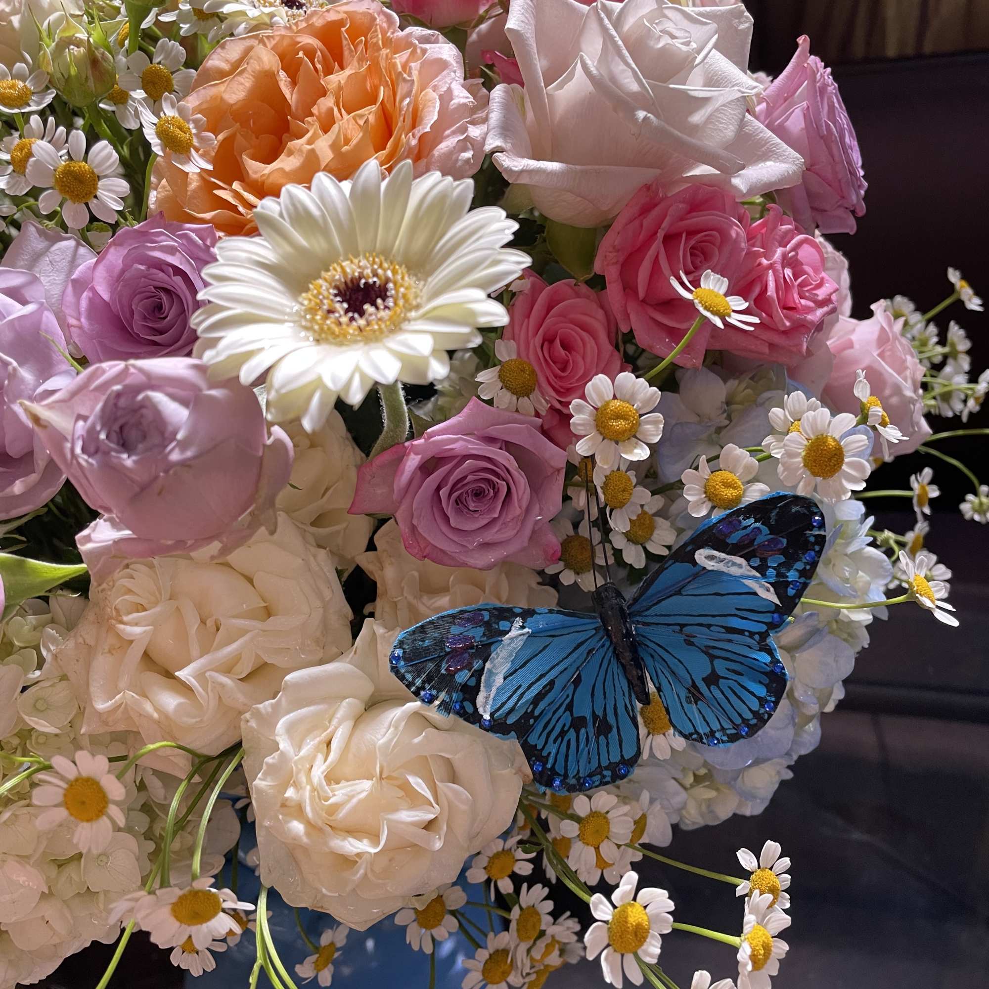 Mixed bouquet of pink and white roses with daisies in a blue vase