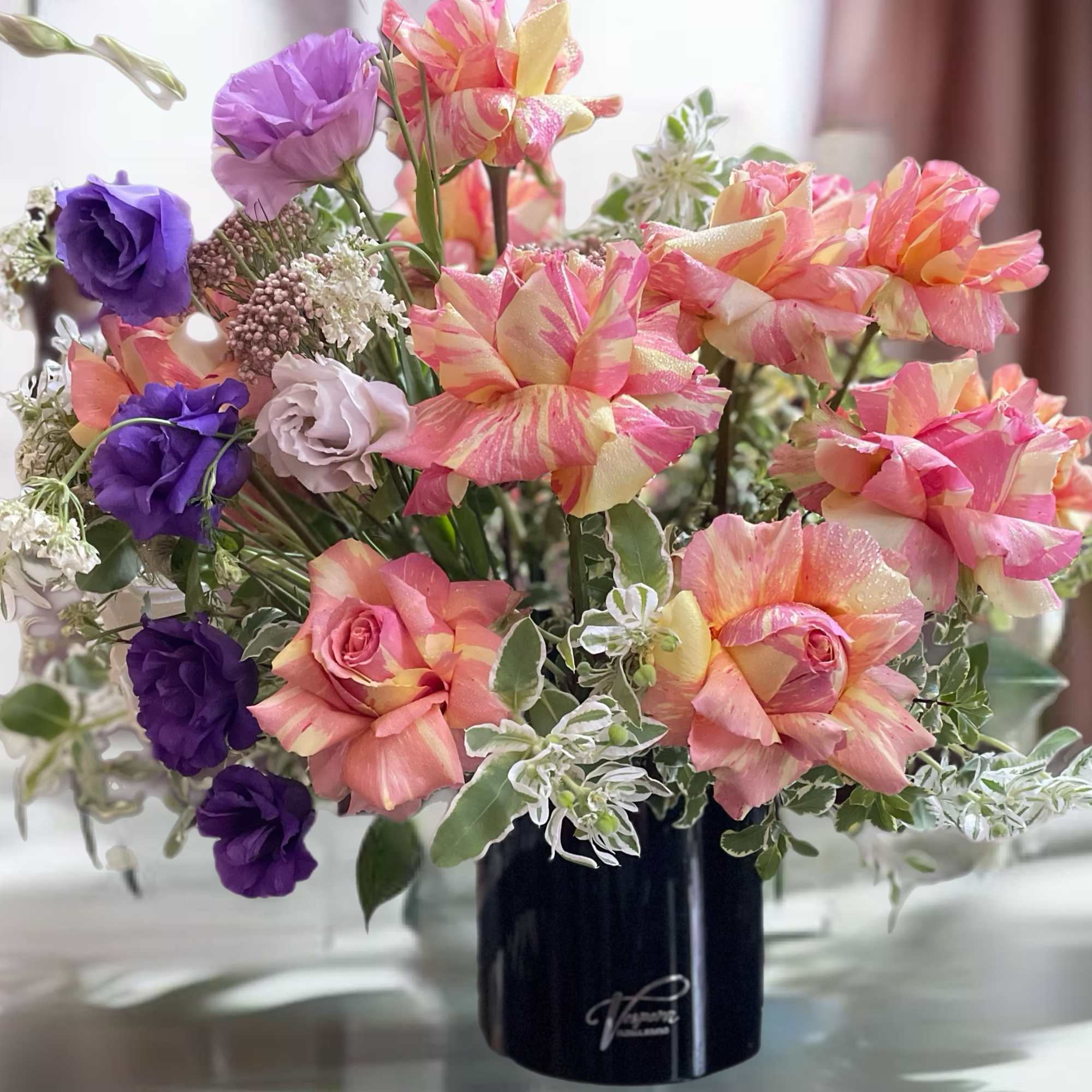 Bouquet of pink and purple flowers in a black vase