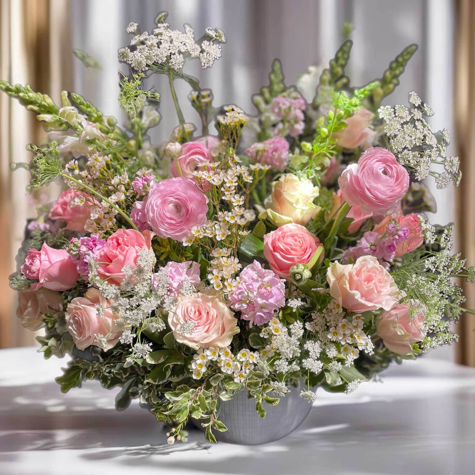 Pink and blush mixed flower arrangement in a gray vase