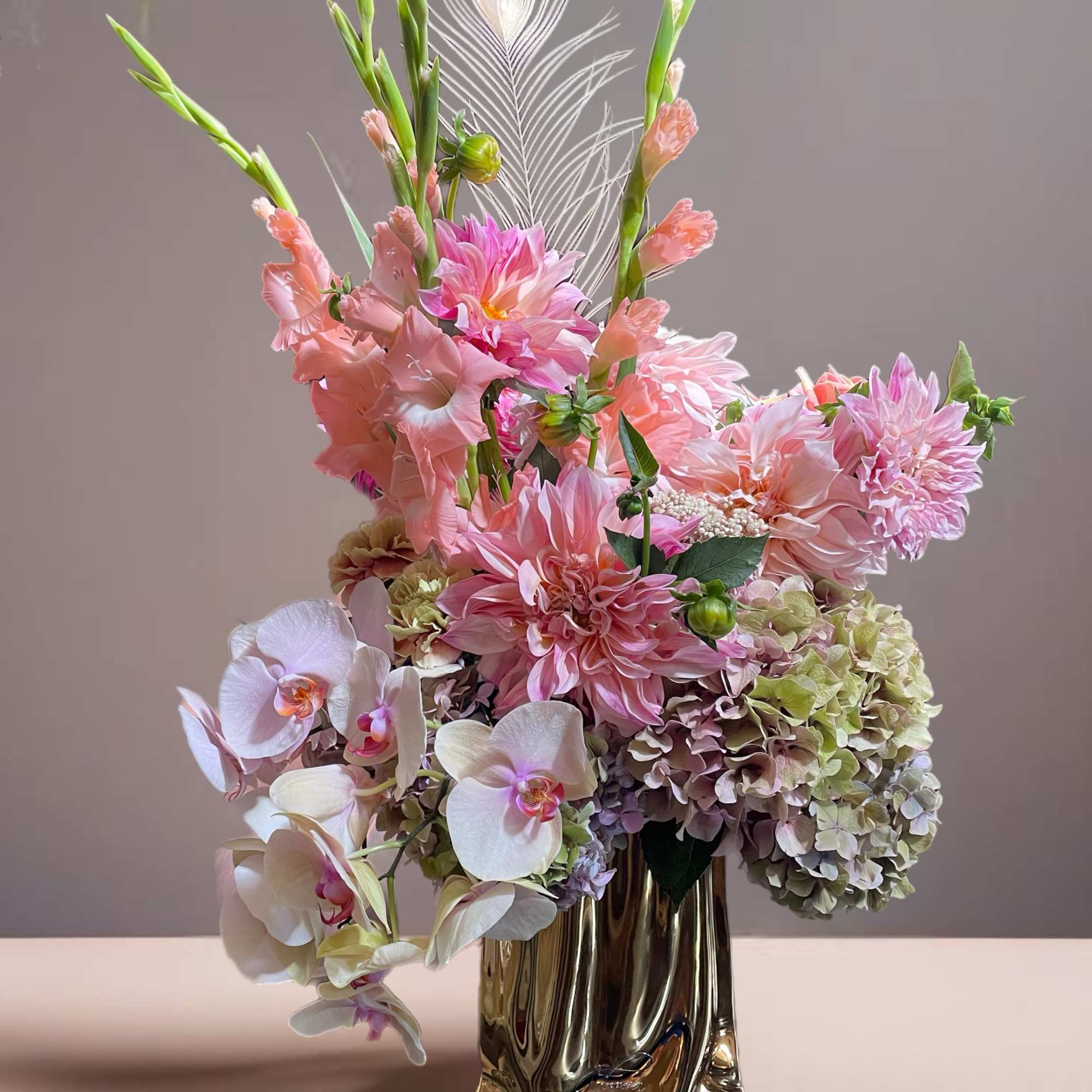 Pink and white floral arrangement in a metallic vase