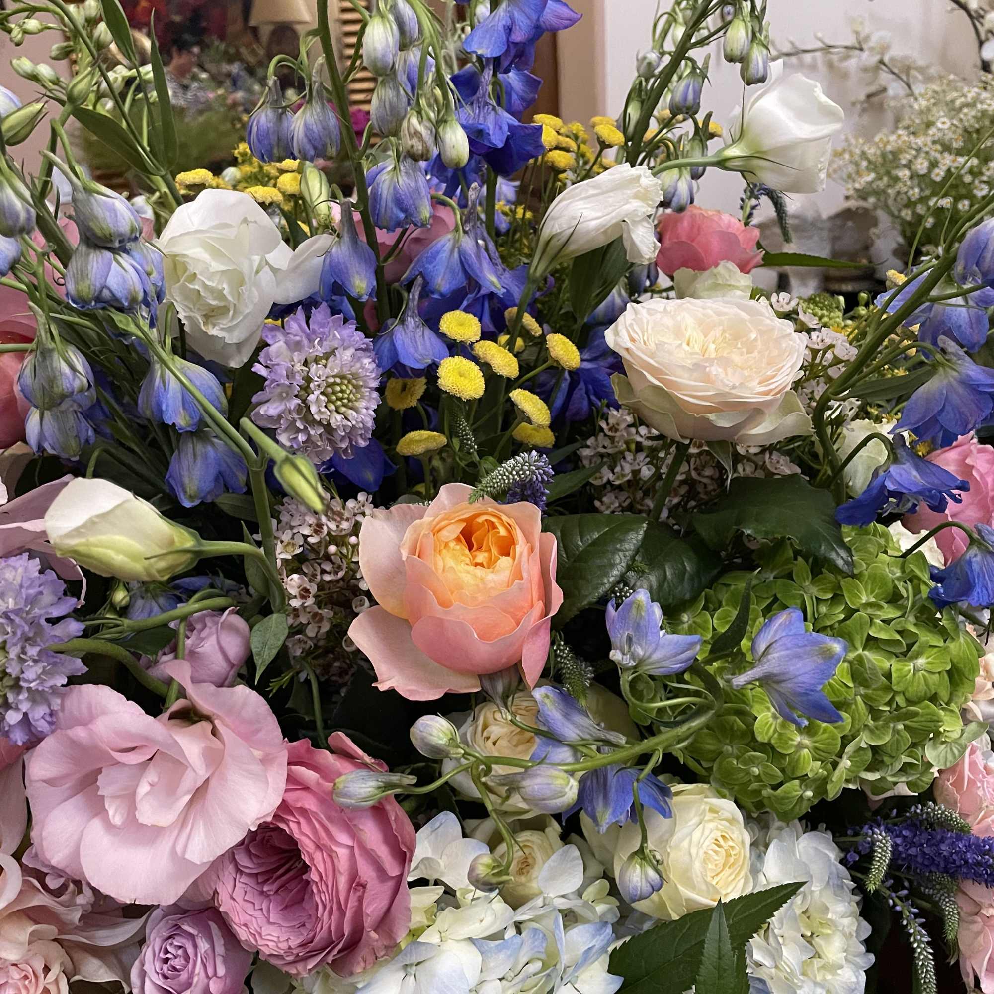 Mixed bouquet with blue bell-shaped flowers, roses, and hydrangeas