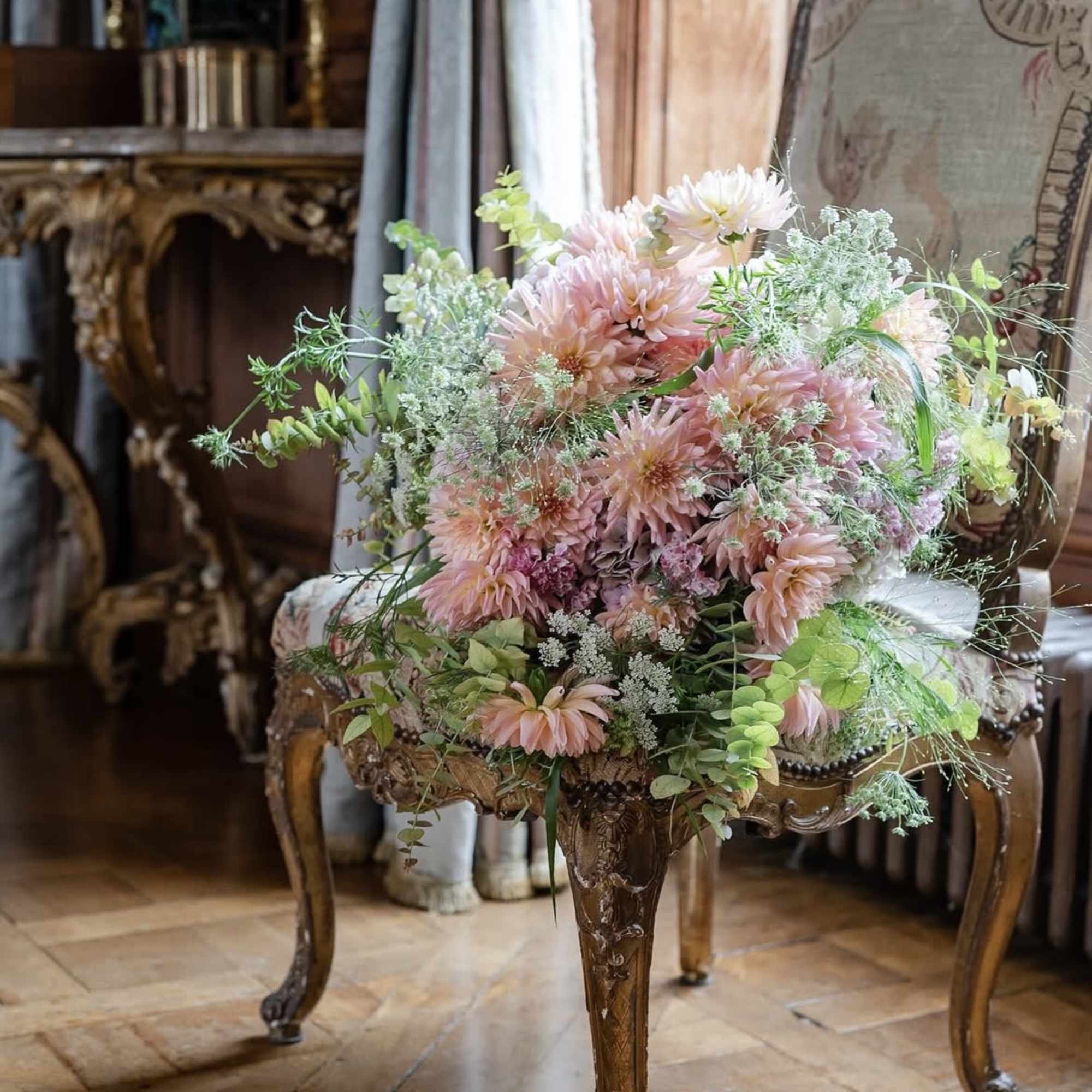 Pink and white flower arrangement on an ornate wooden table