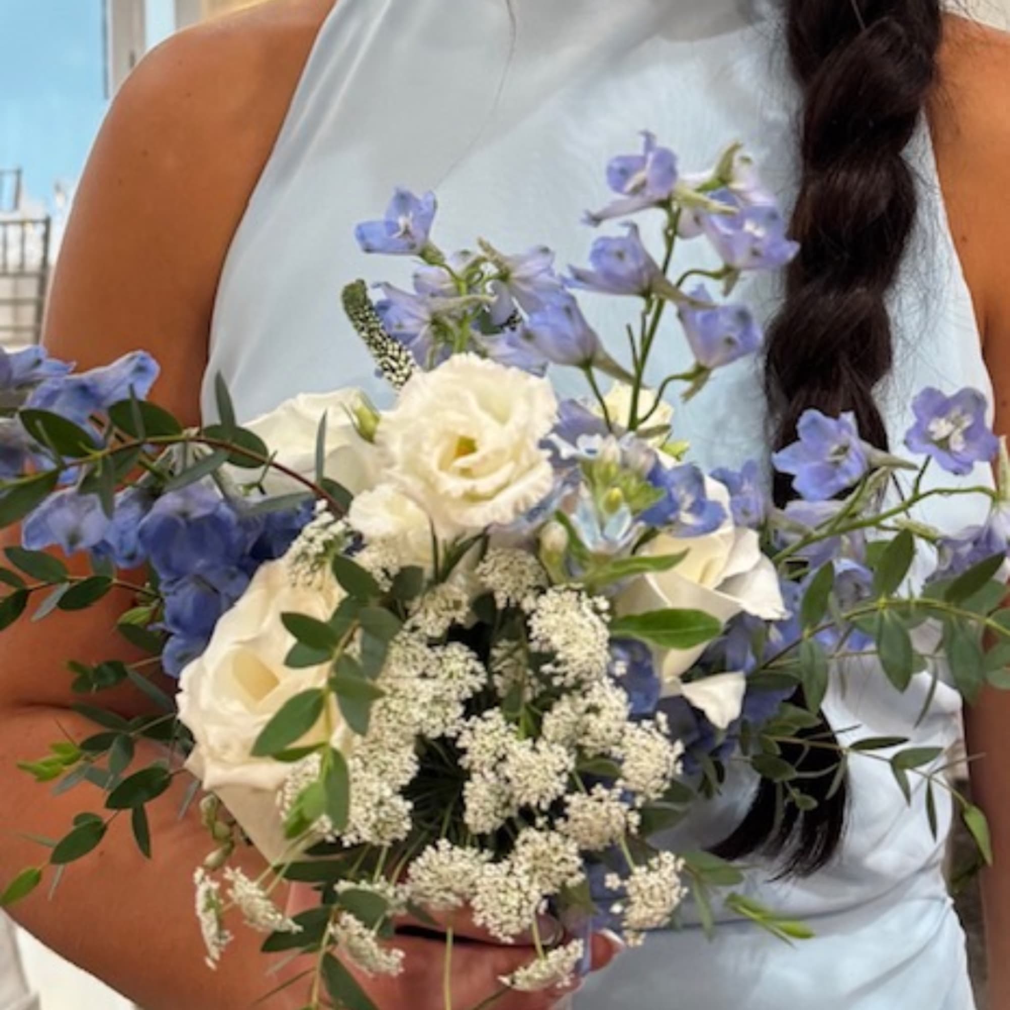Woman holding a bouquet of white and blue flowers