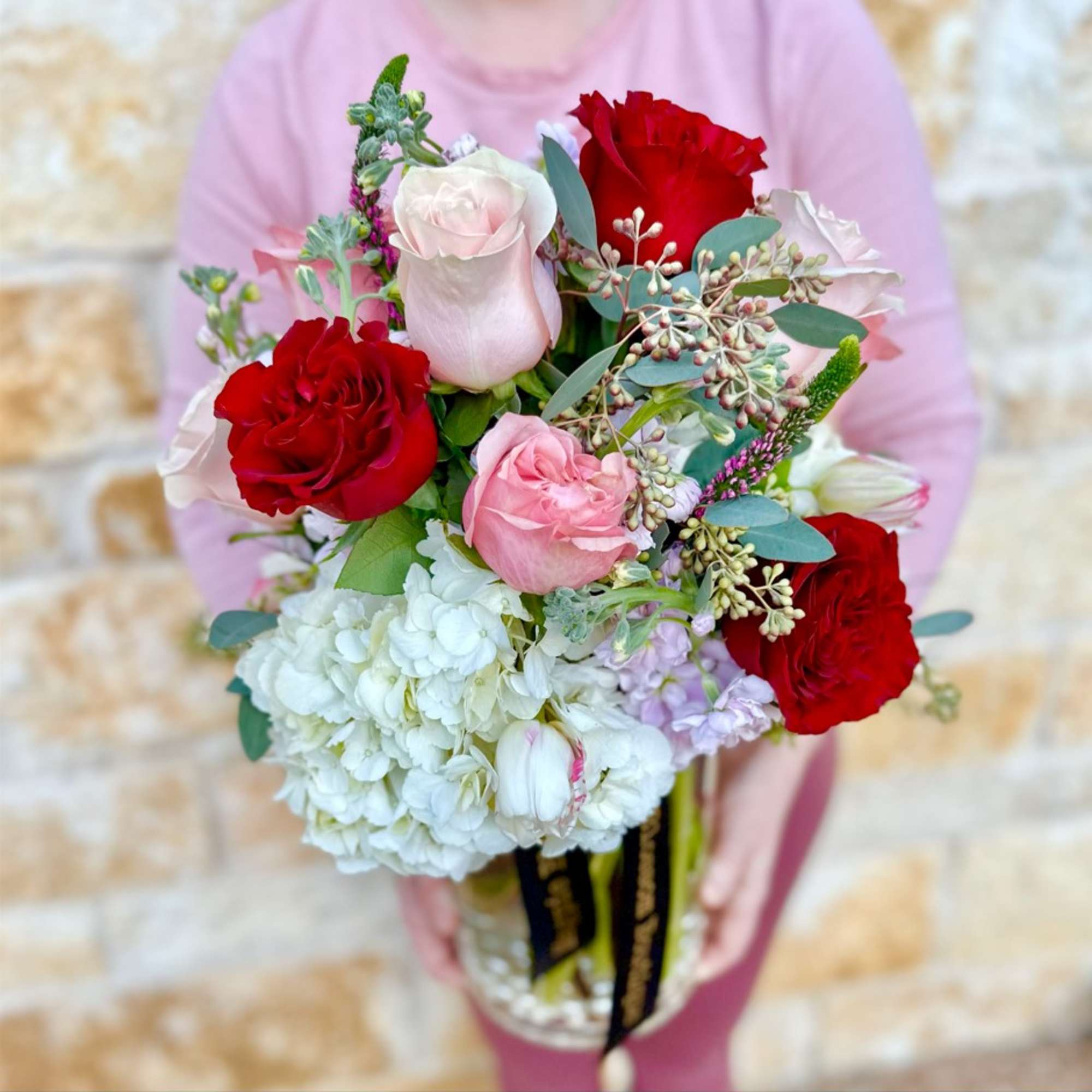 Bouquet of red, pink, and white roses in a glass vase