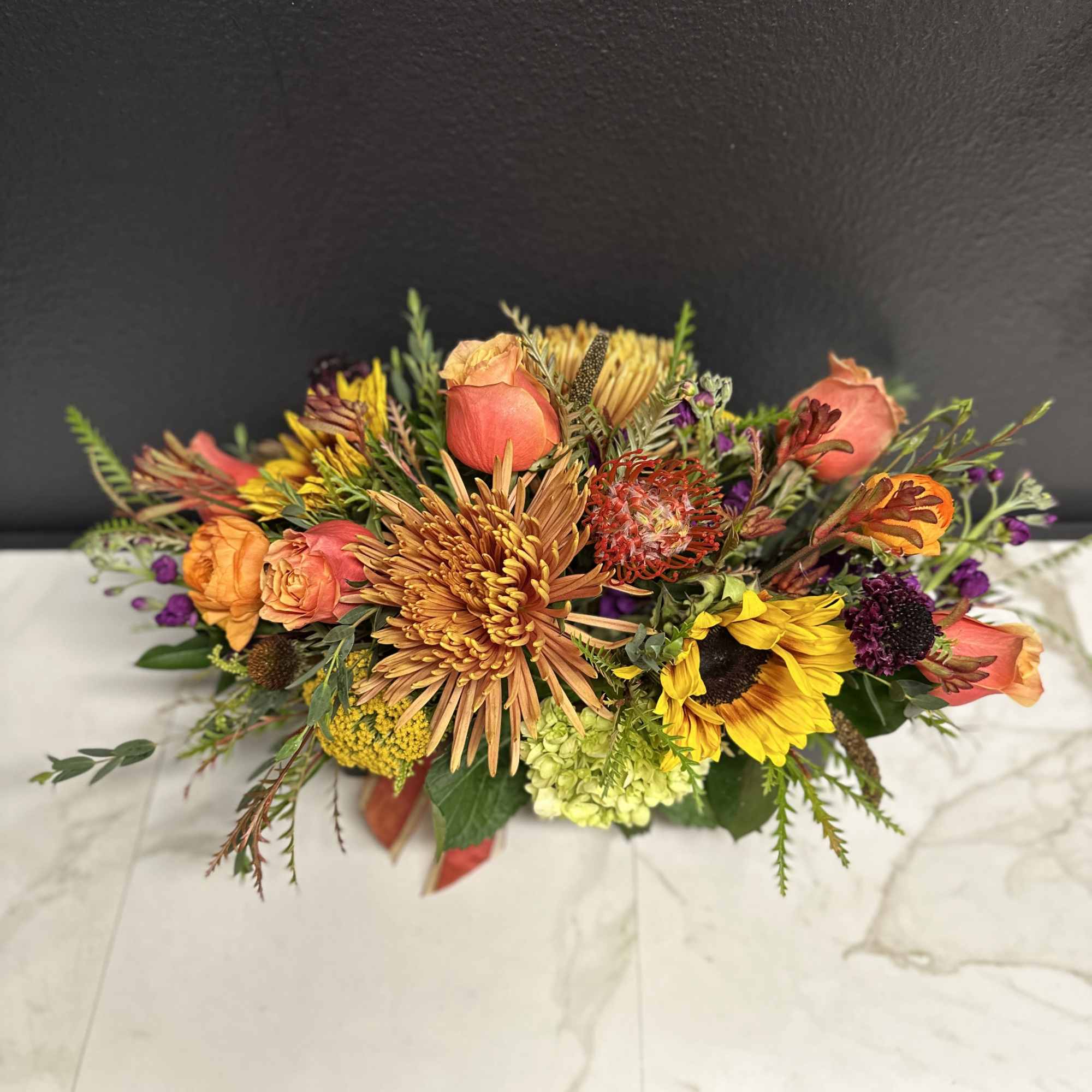 Mixed bouquet with orange roses, sunflowers, and chrysanthemums