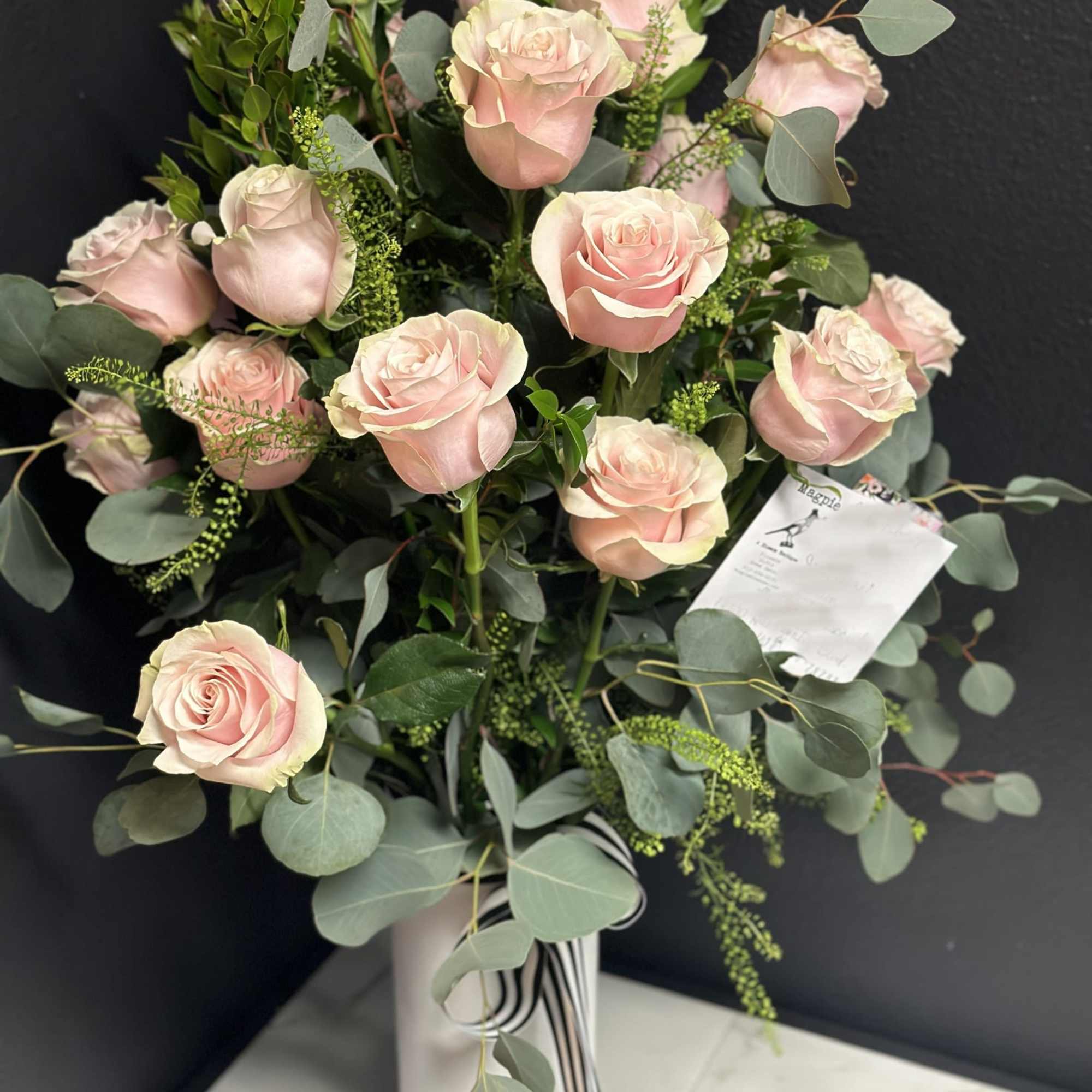 Bouquet of pale pink roses in a white vase