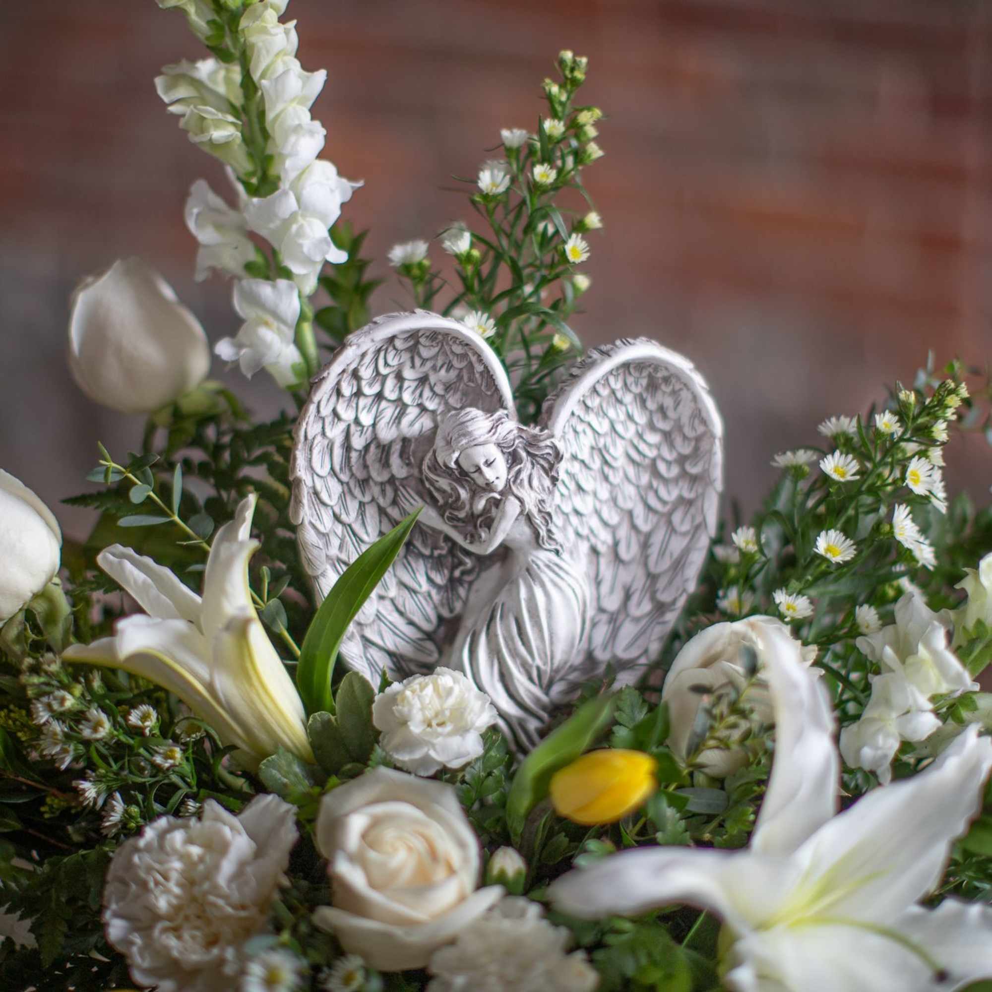 A lovely keepsake resin angel is nested into a garden floral design, photo 2 of 4
