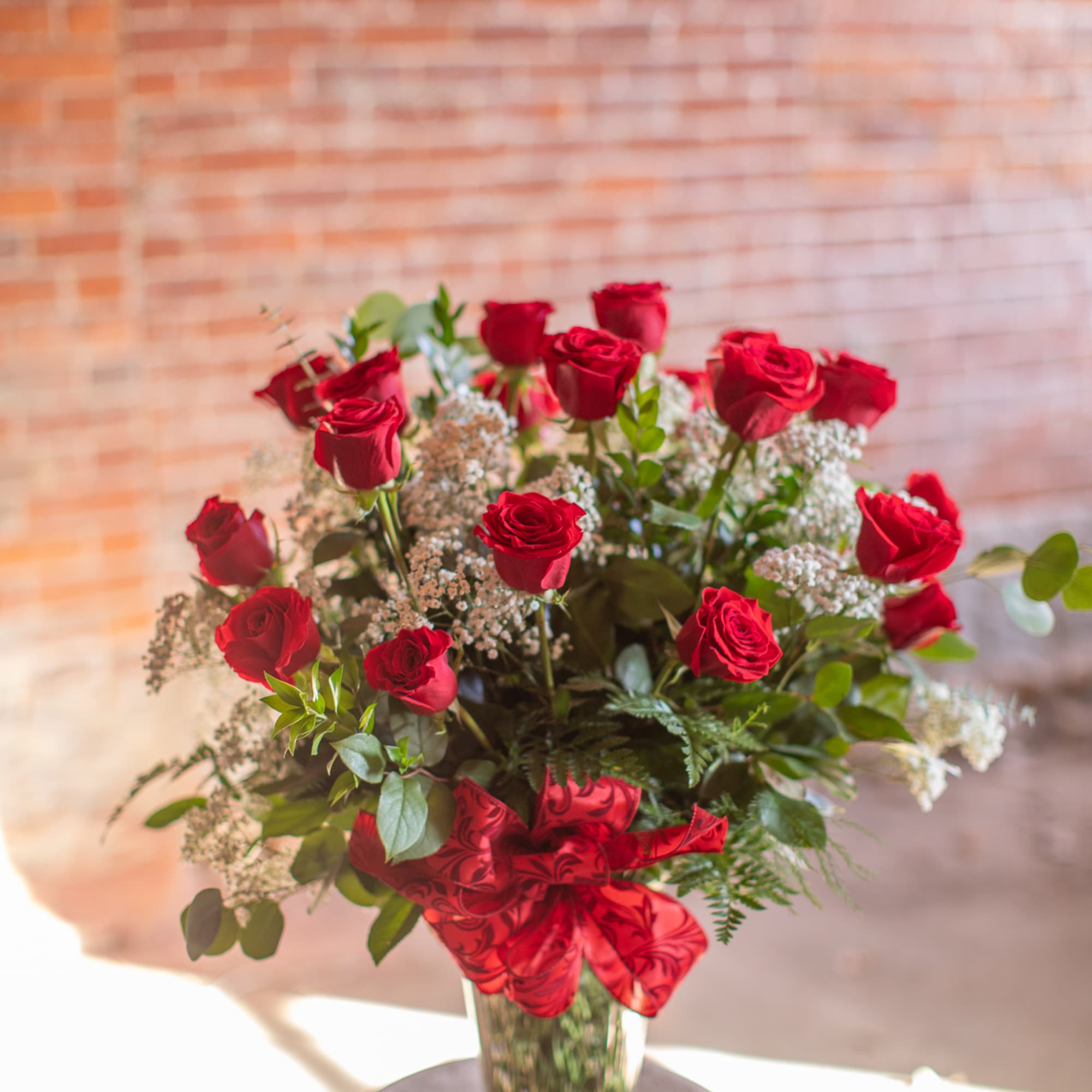 Bouquet of red roses in a clear glass vase with a red ribbon, photo 4 of 4