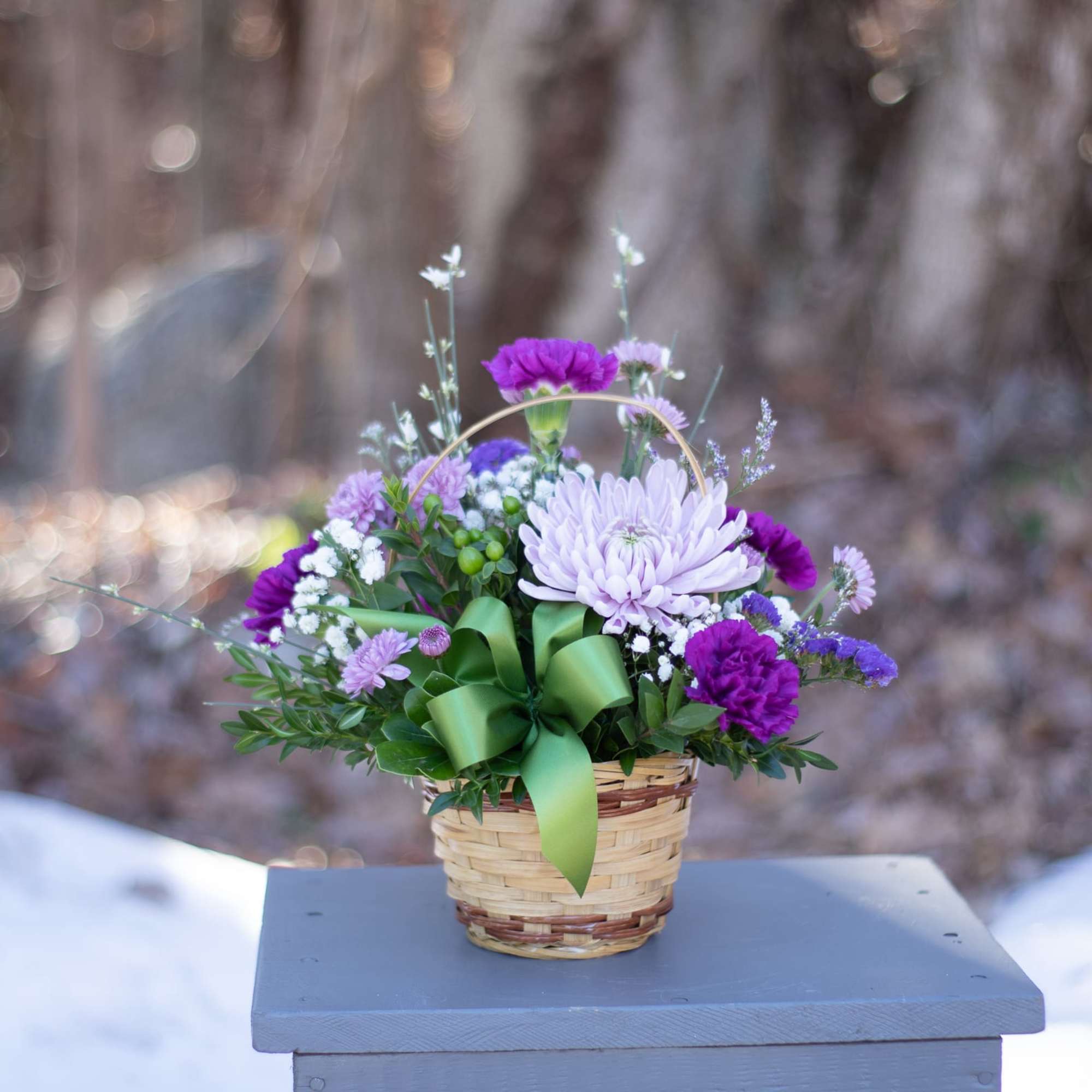 Basket arrangement of purple and lavender flowers with a green ribbon, photo 3 of 3