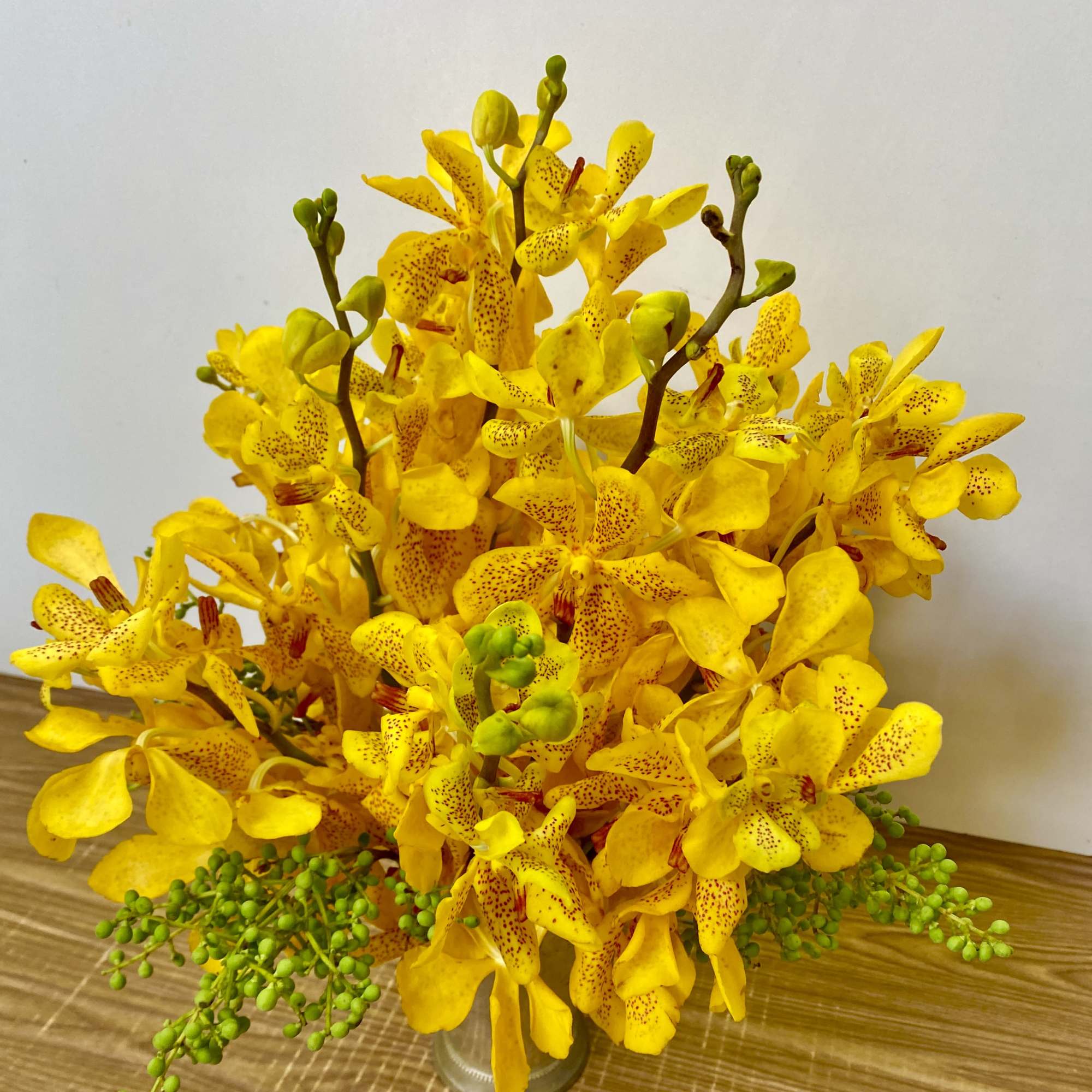 Yellow orchid arrangement in a clear glass vase