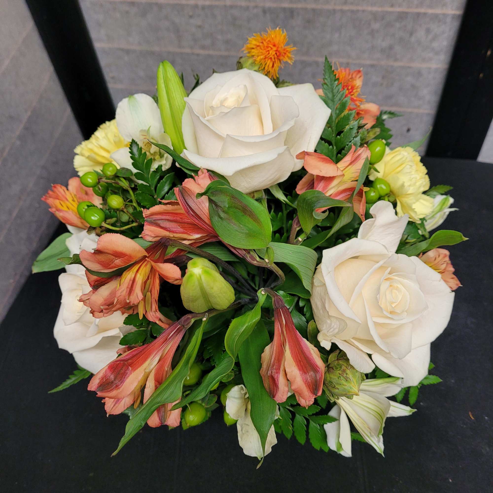 Bouquet of white roses, peach alstroemeria, and yellow blooms