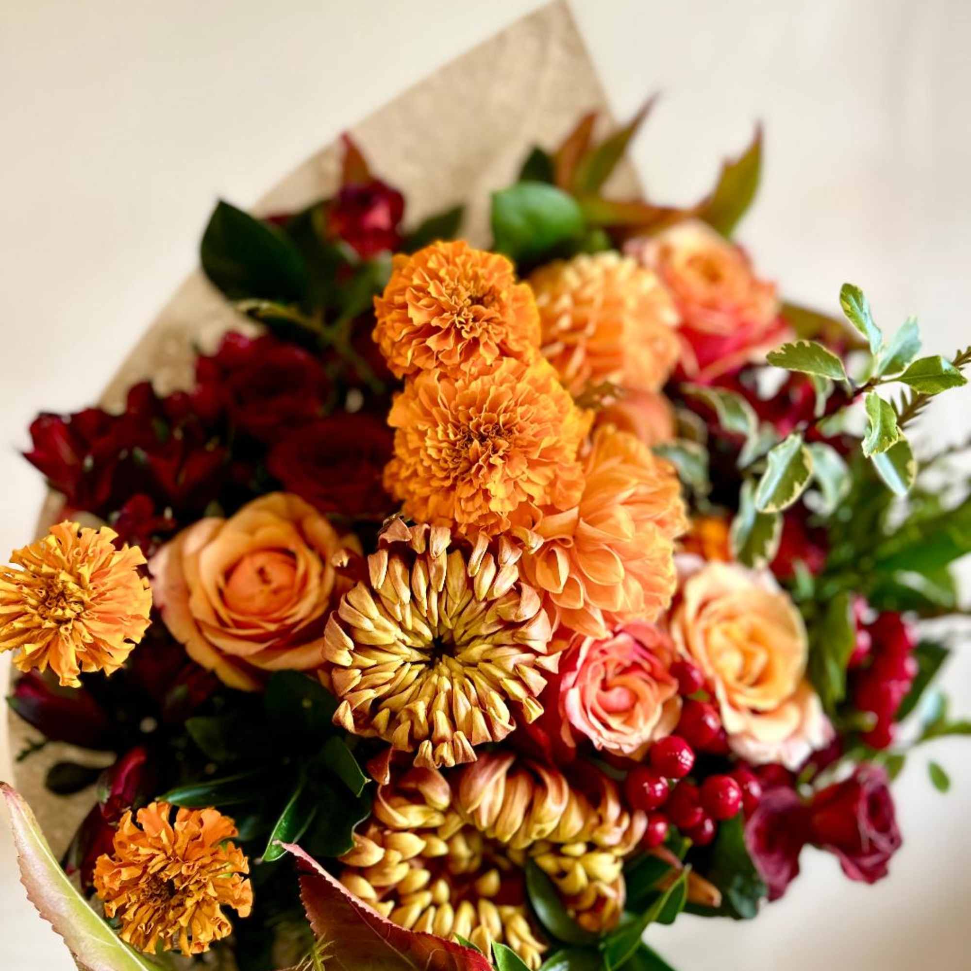 Bouquet of orange and red flowers wrapped in paper