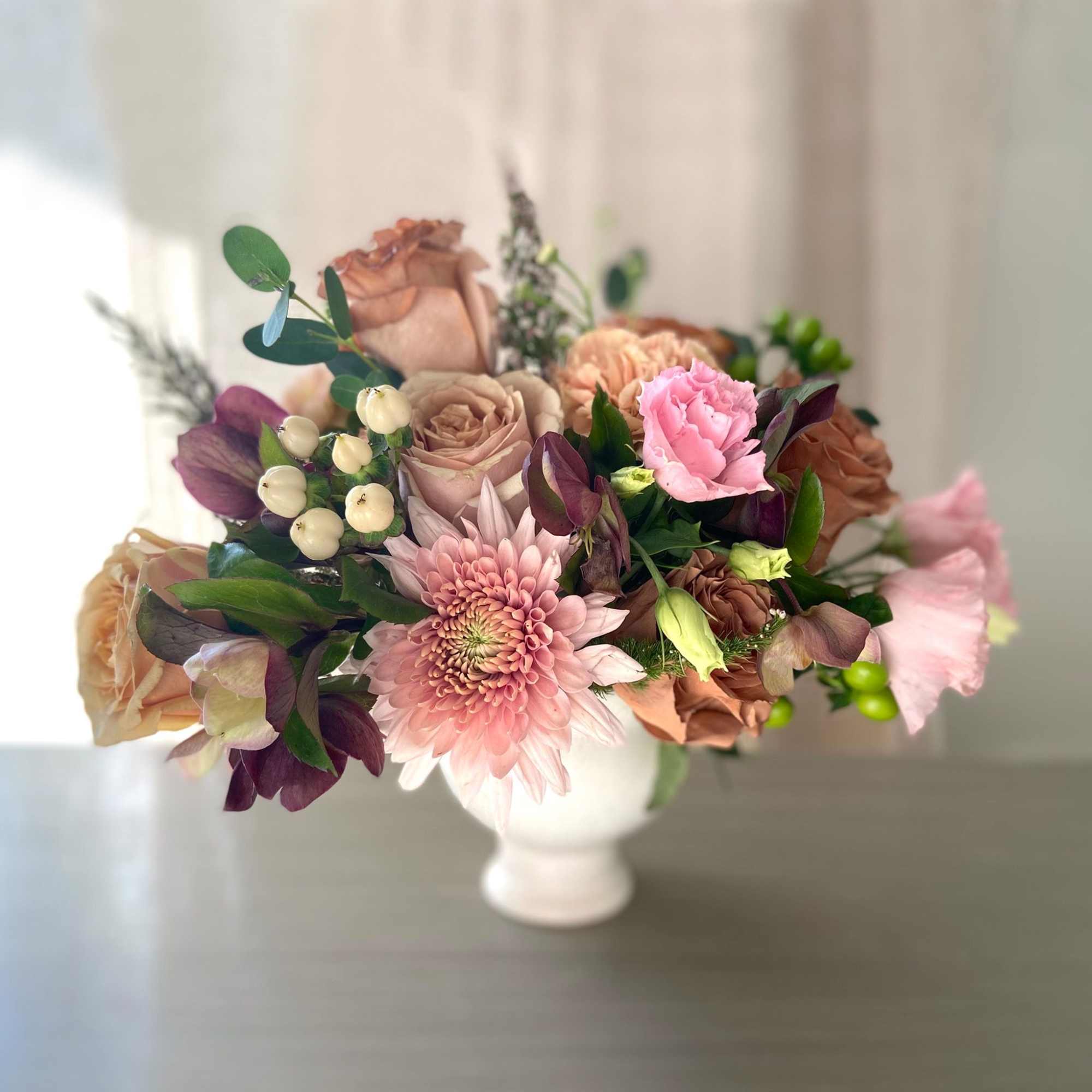 Bouquet of pink and tan flowers in a white vase