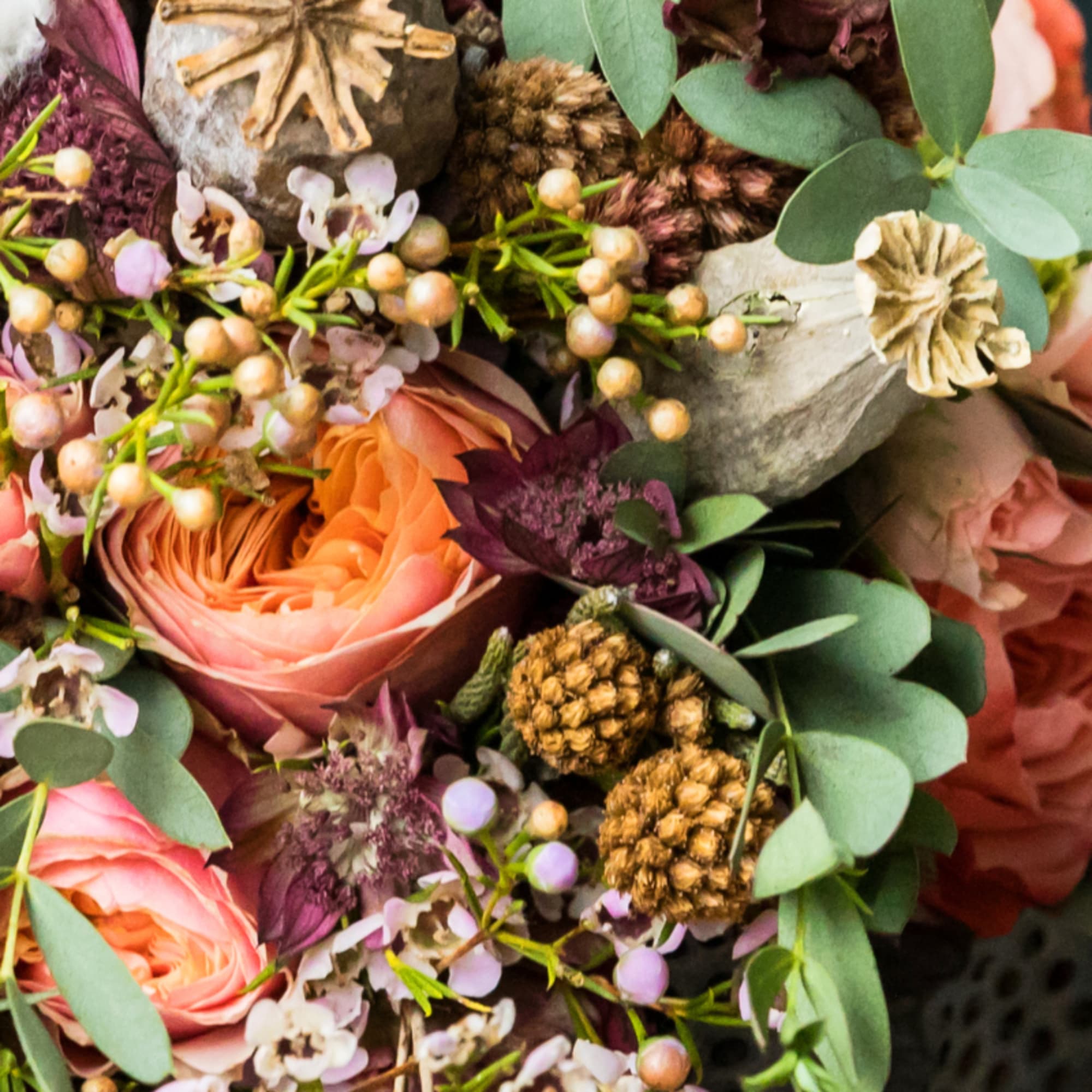 Close-up bouquet with peach roses, purple accents, and eucalyptus