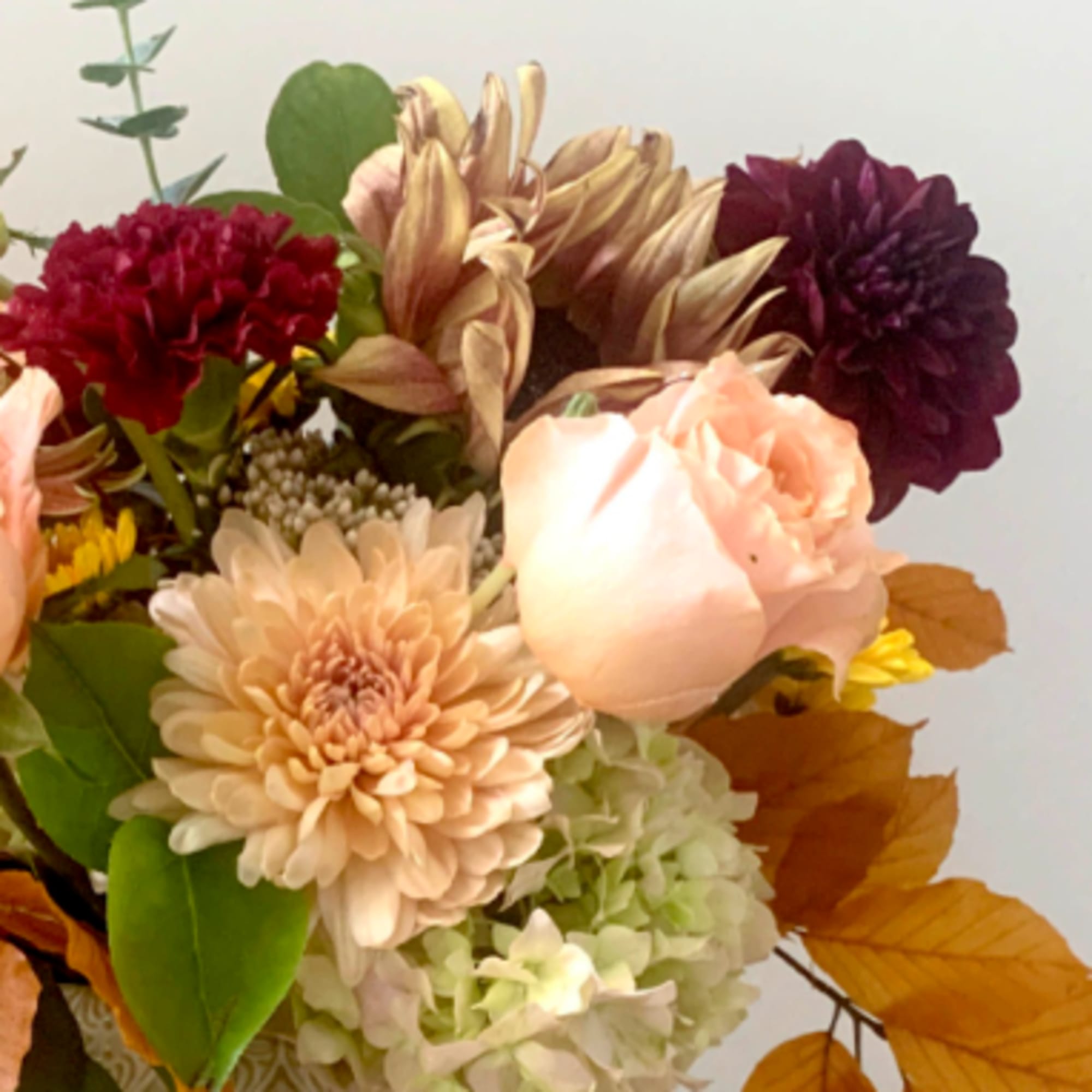 Mixed bouquet with peach, burgundy, and cream flowers