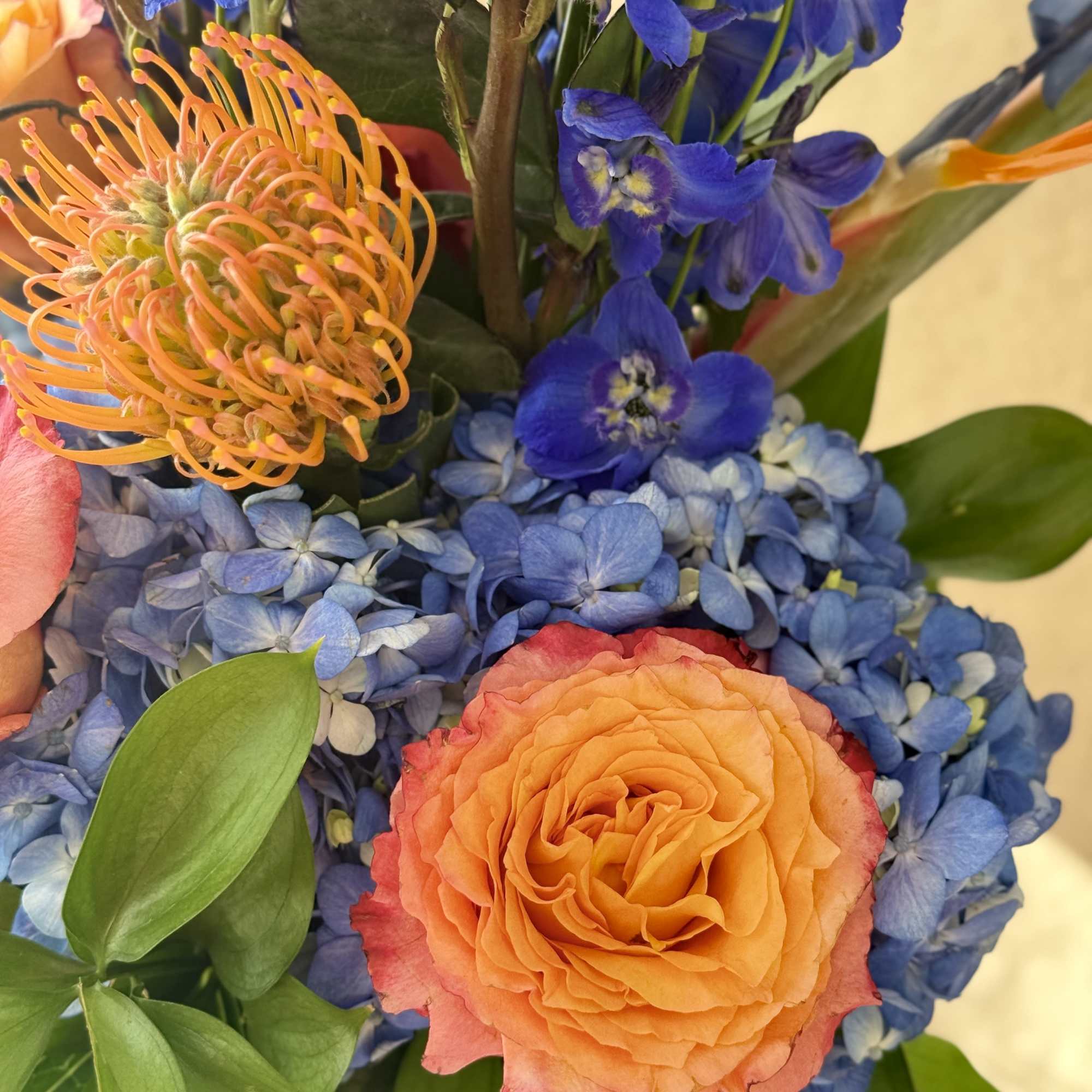 Blue and orange with Birds of Paradise, Hydrangeas, Delphinium and Roses arranged