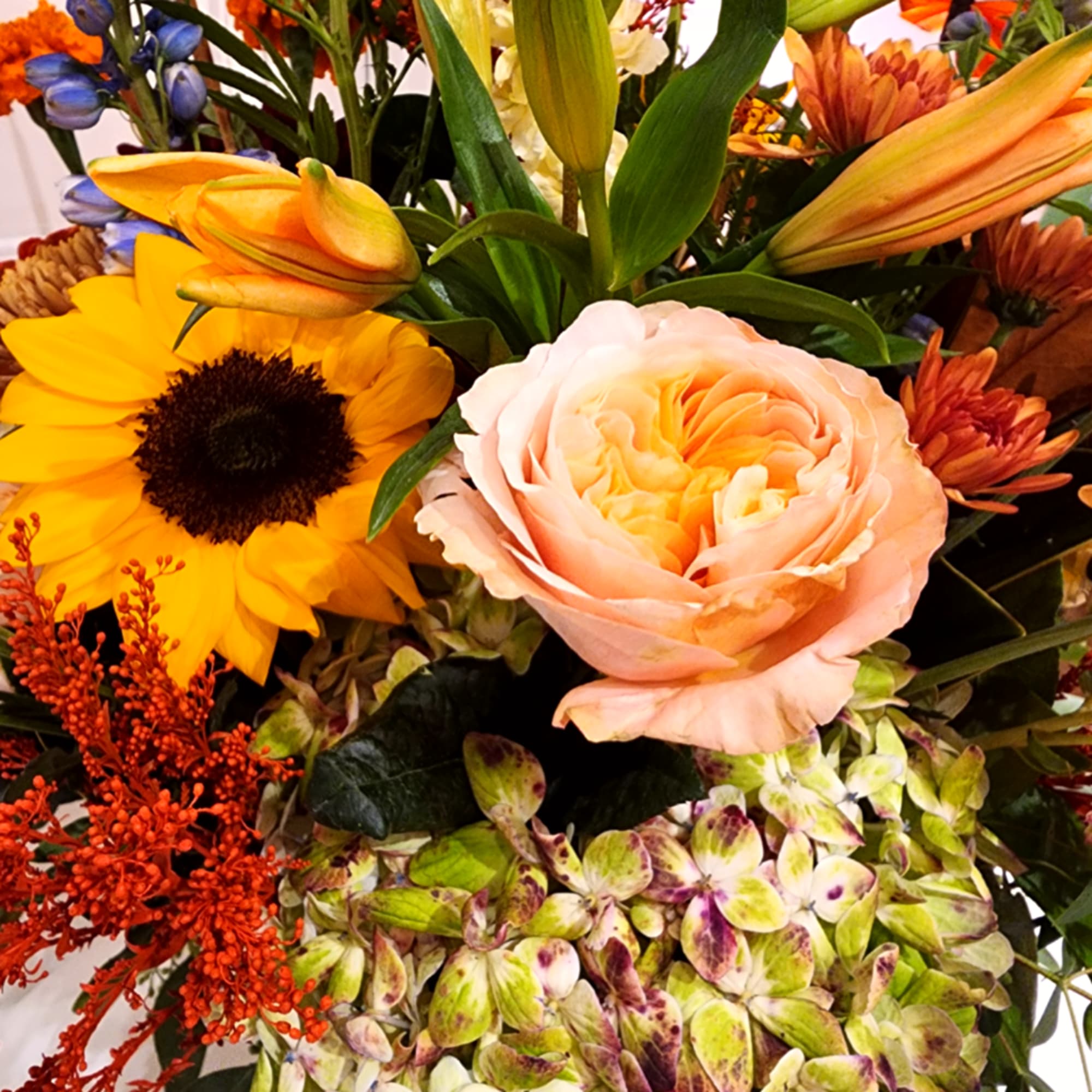 Mixed bouquet with sunflower, peach rose, lilies, and hydrangea