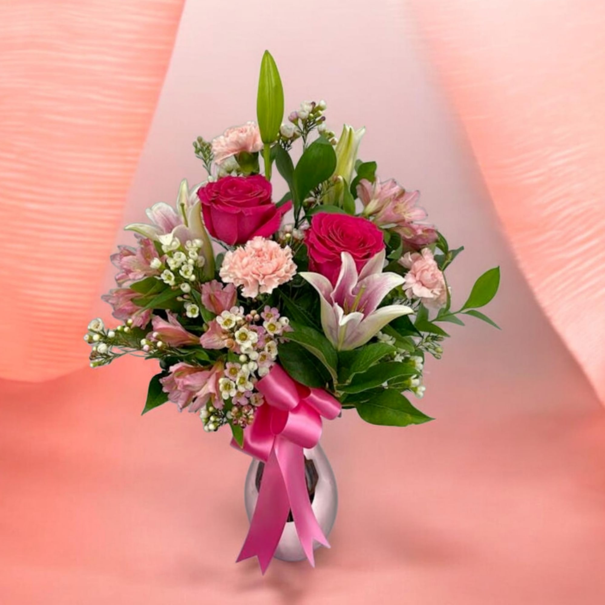 A lush mix of deep red roses and soft pink lilies and
