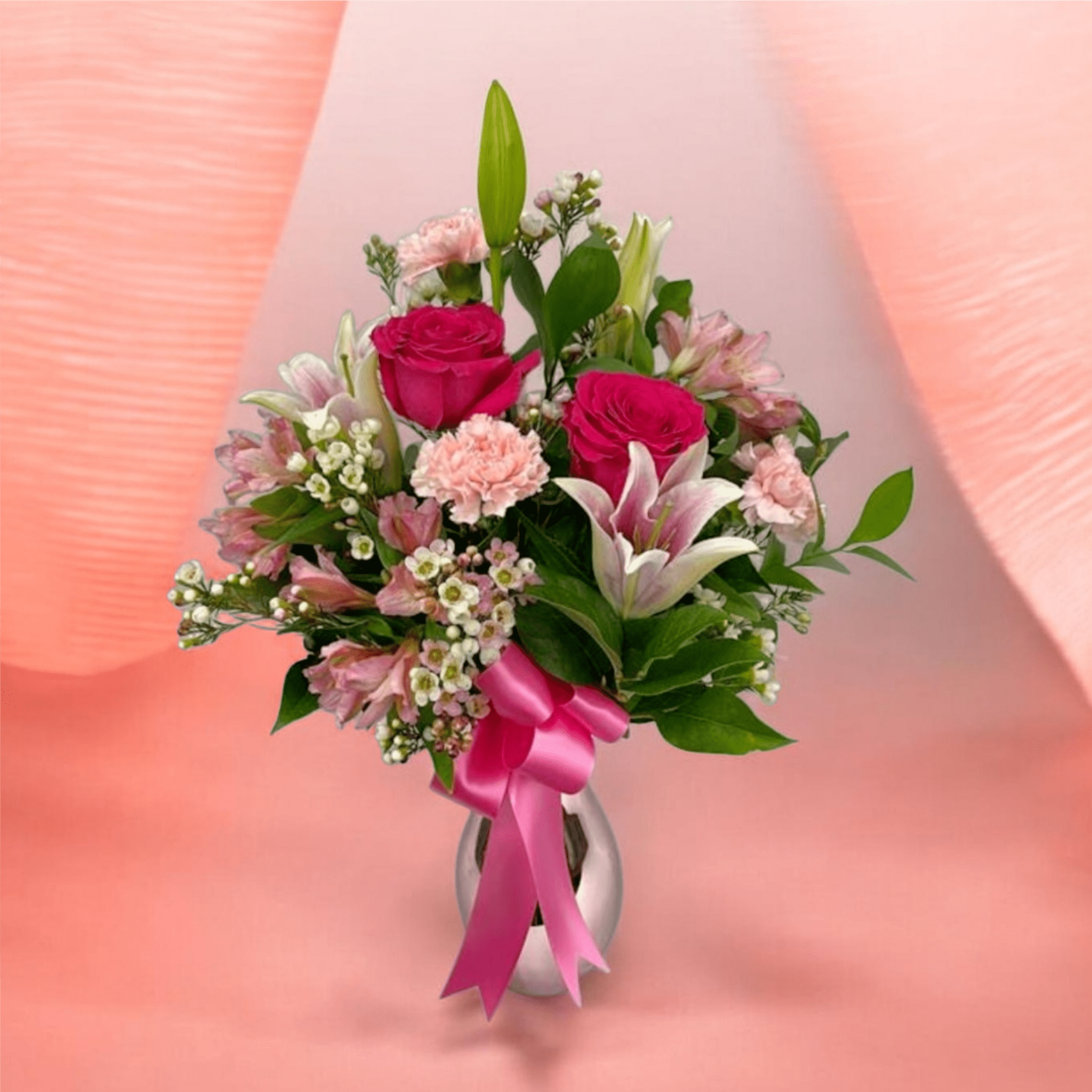 A lush mix of deep red roses and soft pink lilies and