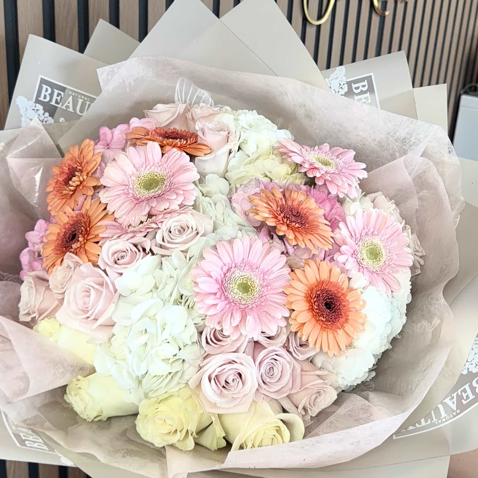 Soft, romantic pastels take center stage in this gerbera-and-hydrangea hand-tied bouquet-perfect as