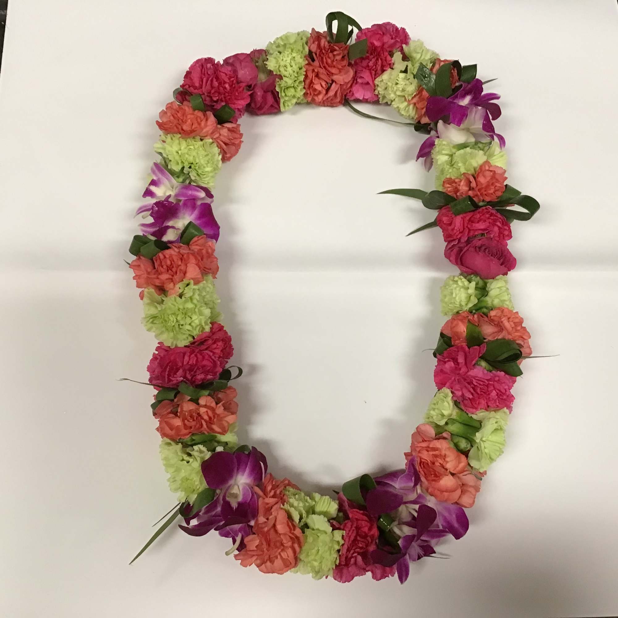 Floral lei with pink, coral, green, and purple flowers