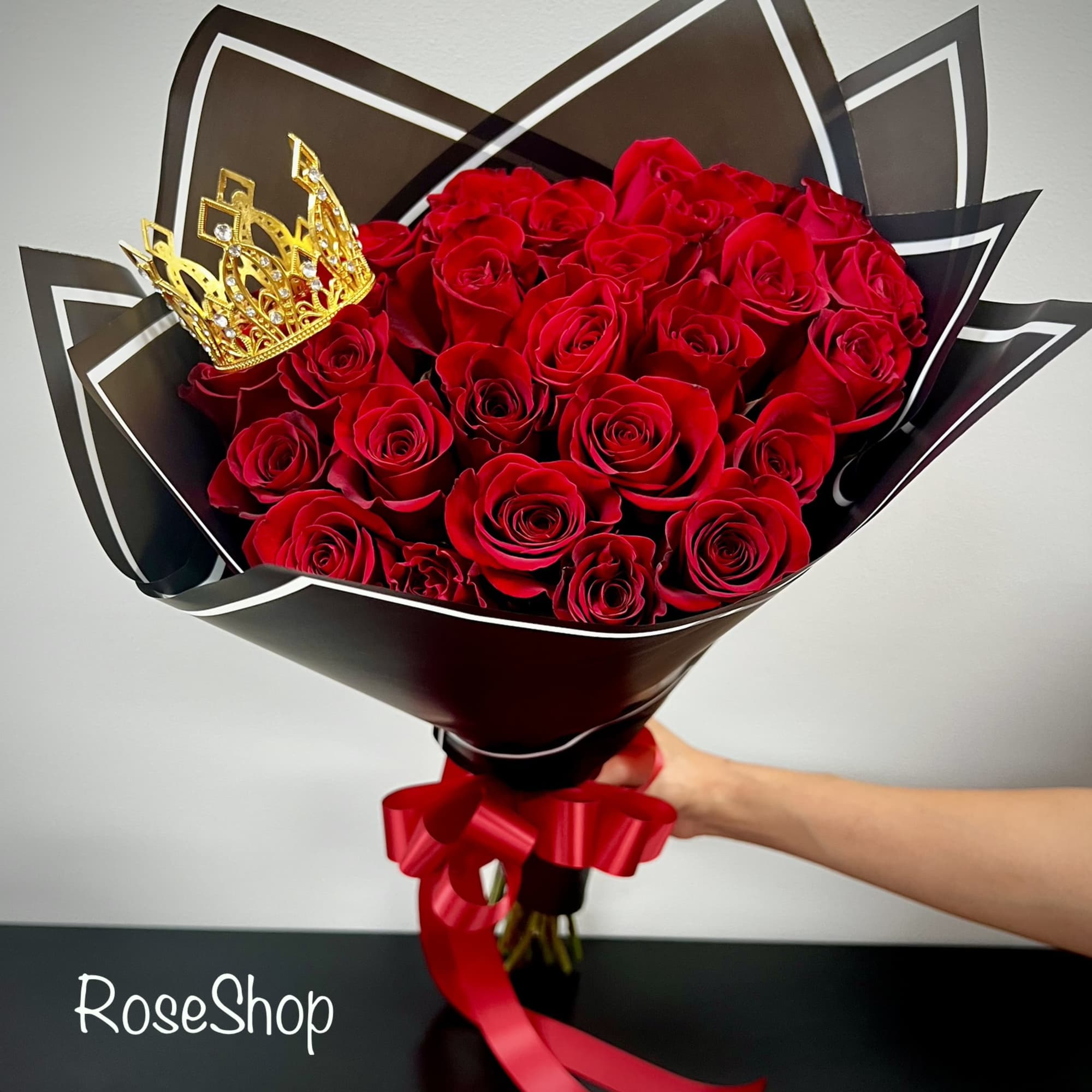 Bouquet of red roses with a gold crown and red ribbon wrap