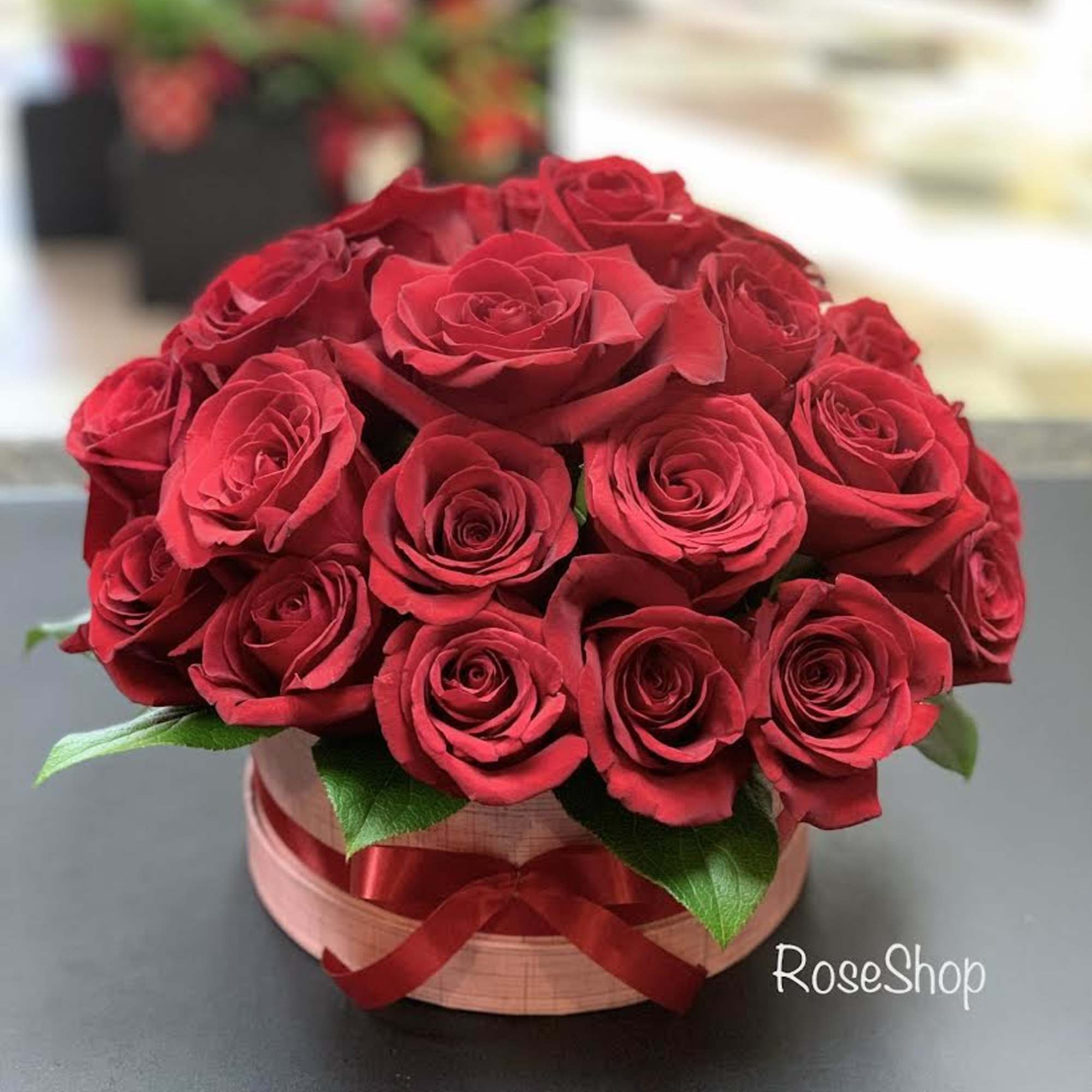 Bouquet of red roses in a round box with a ribbon
