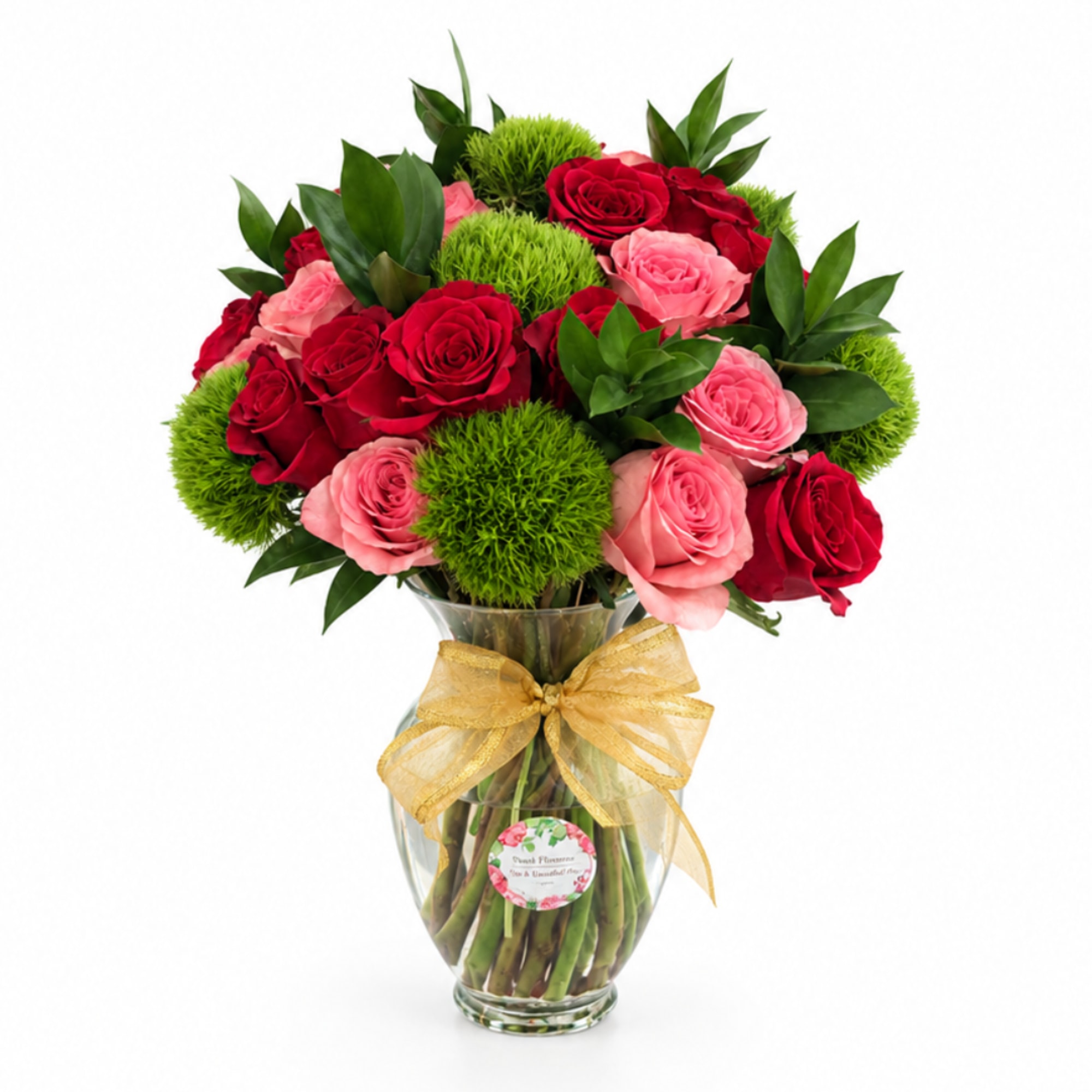 Bouquet of red and pink roses in a glass vase with a gold ribbon
