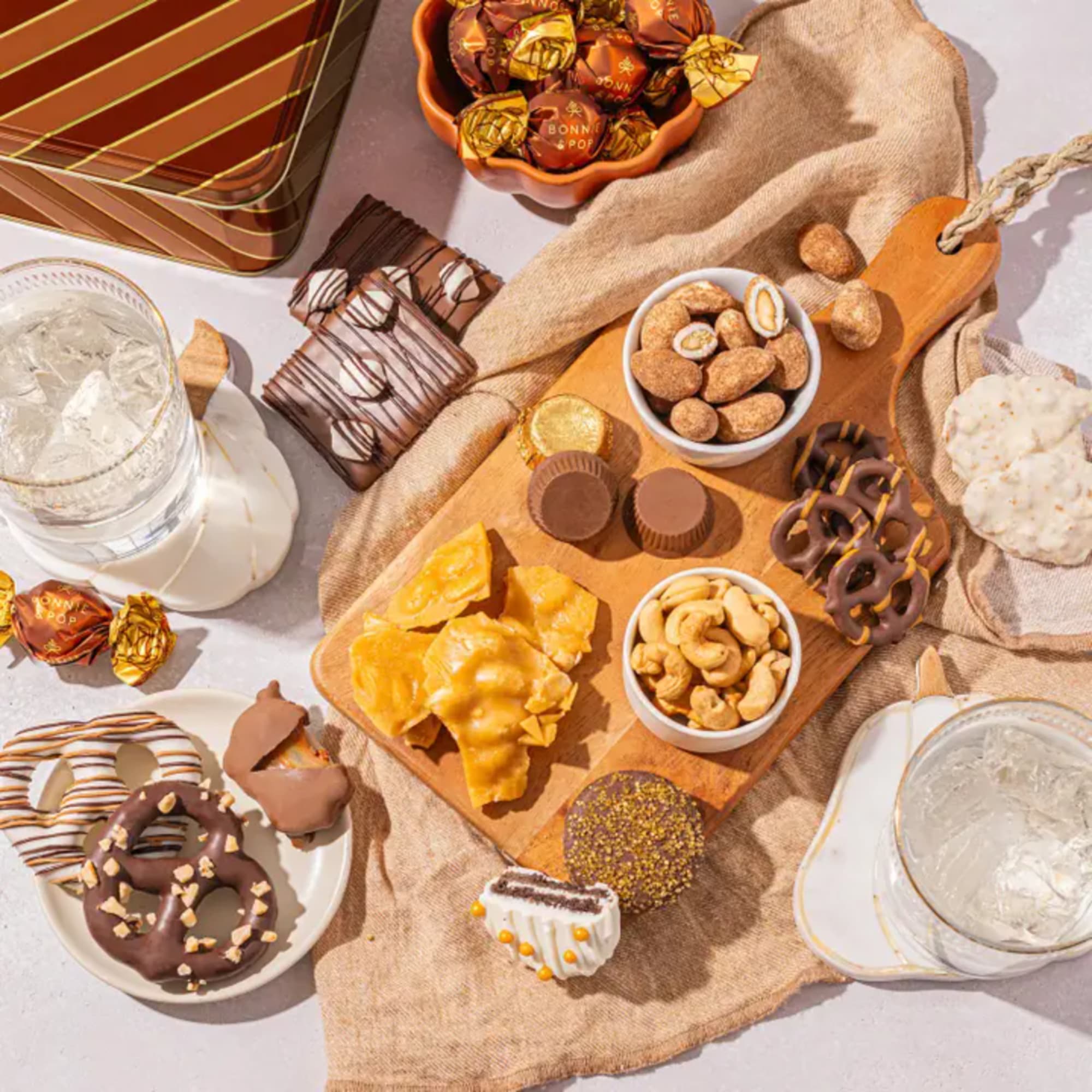 Assorted chocolates, nuts, and pretzels arranged with two glasses of ice water