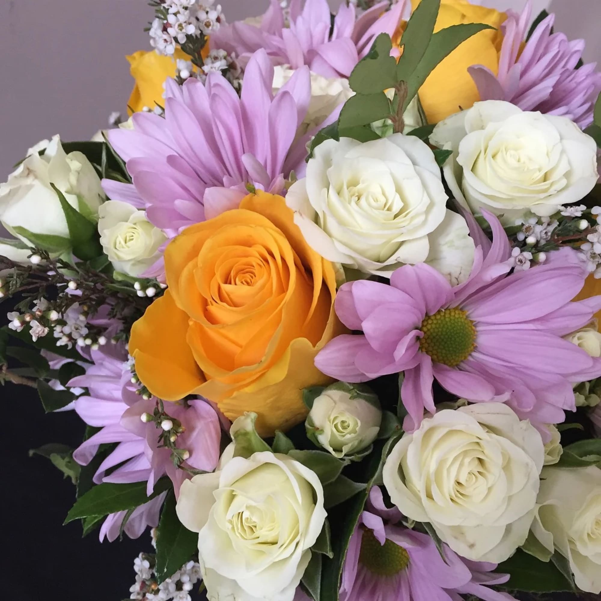 Bouquet of white and orange roses with lavender daisies