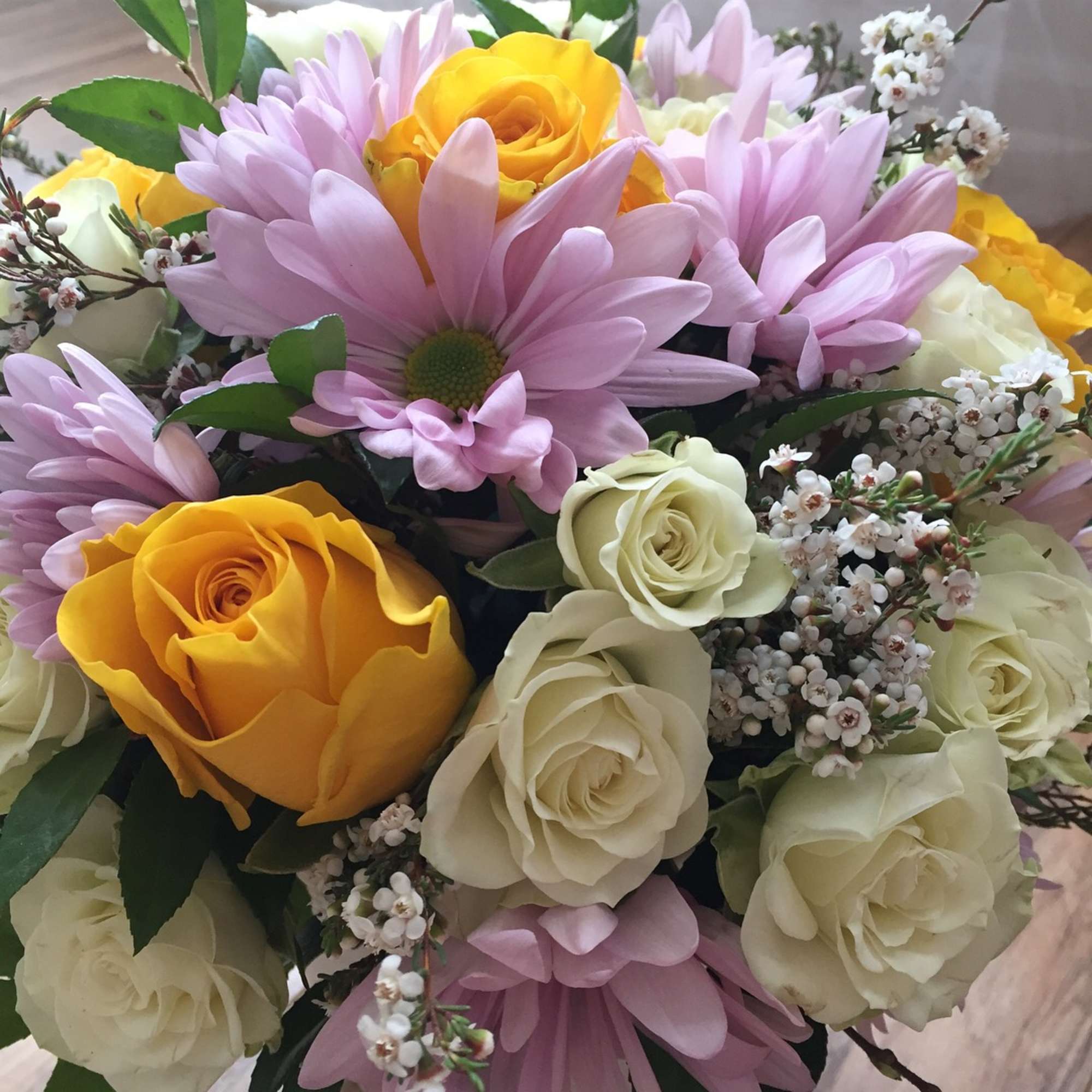 Bouquet of yellow and white roses with pink daisies
