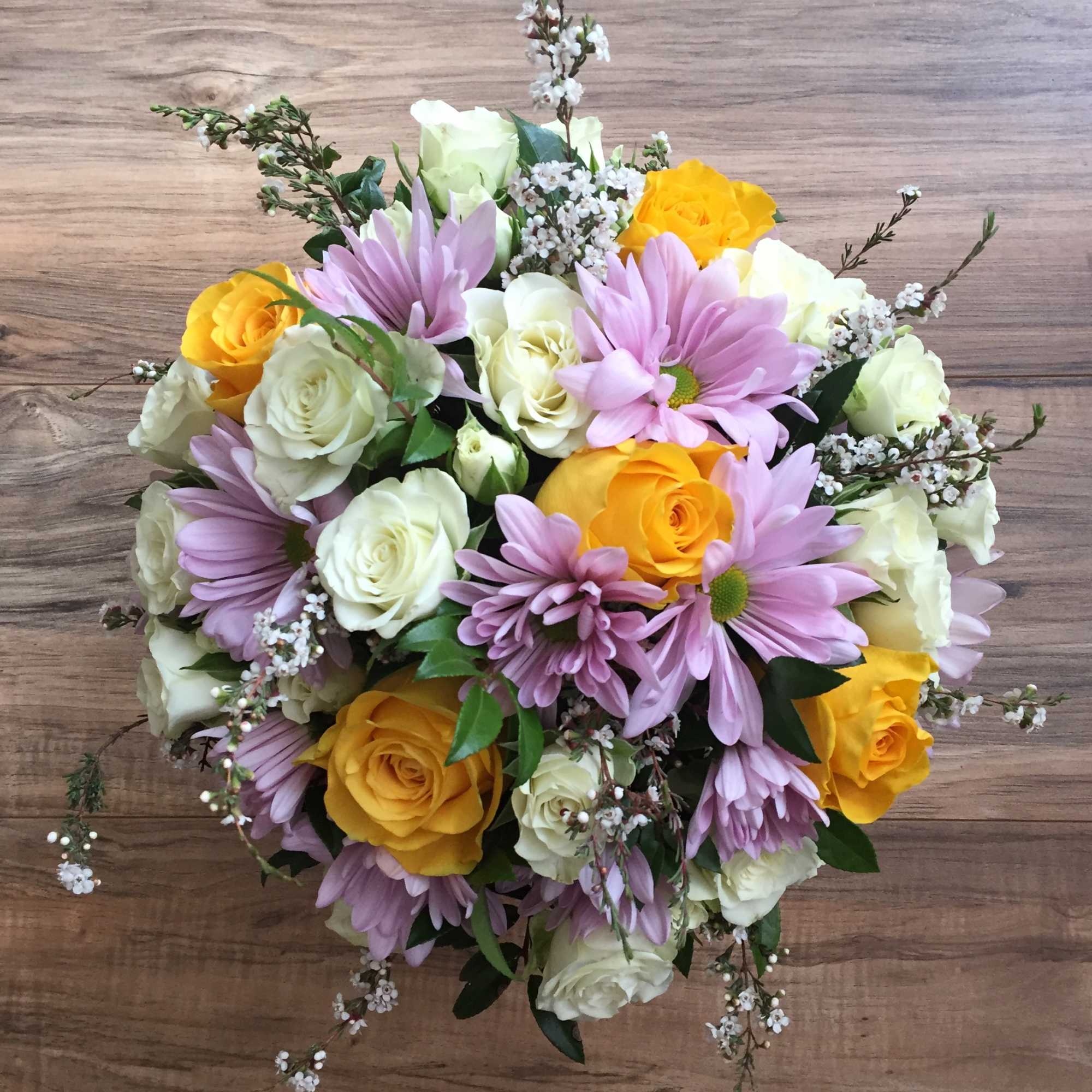 Bouquet of yellow and white roses with lavender daisies