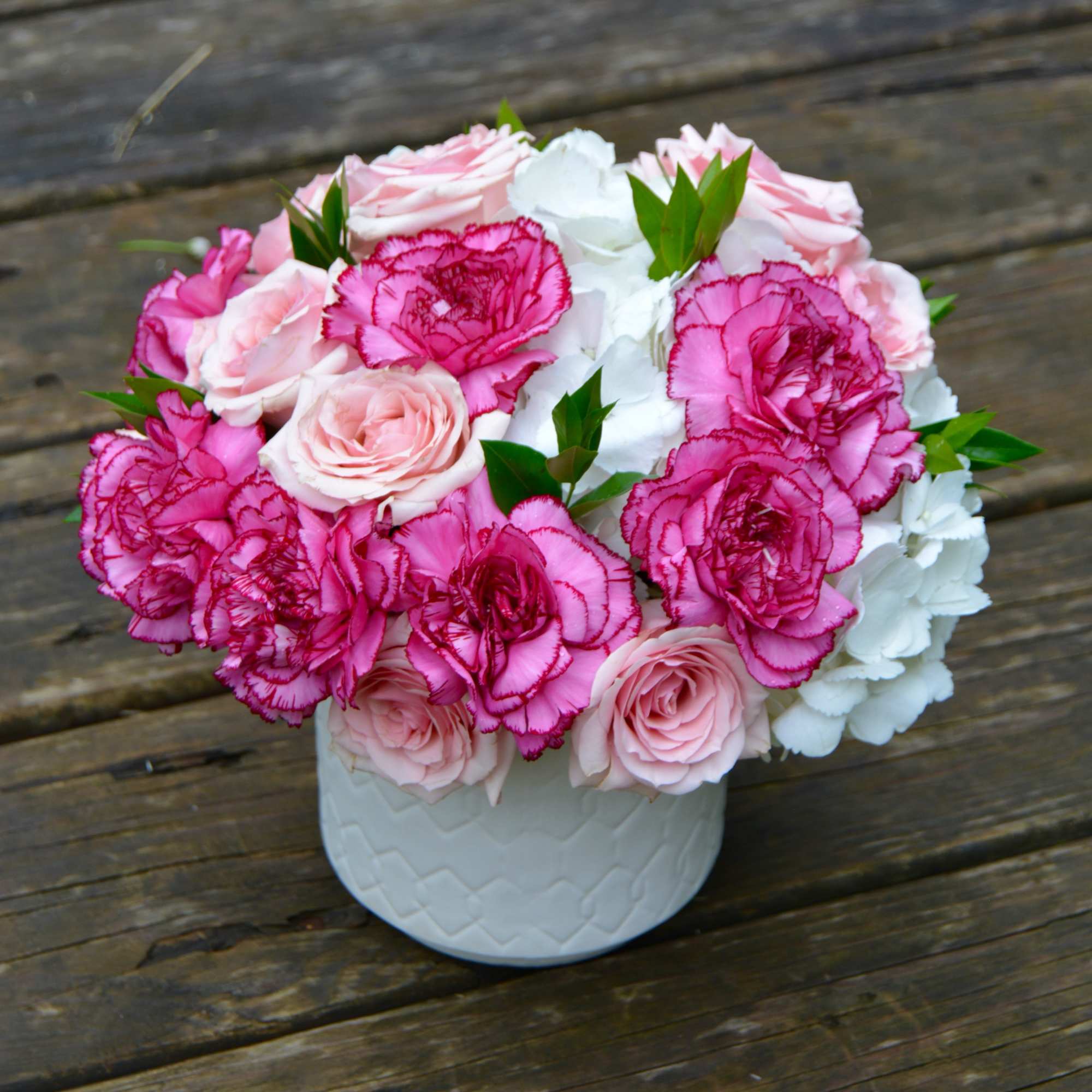 Pink and white floral arrangement in a white vase