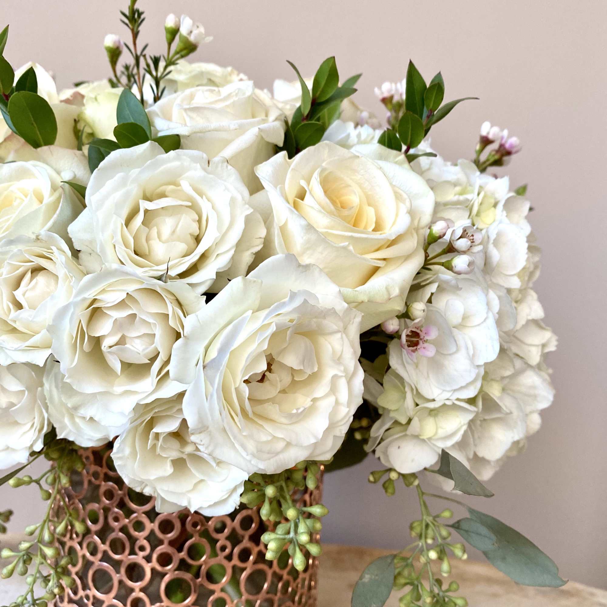 White rose bouquet in a copper lattice vase