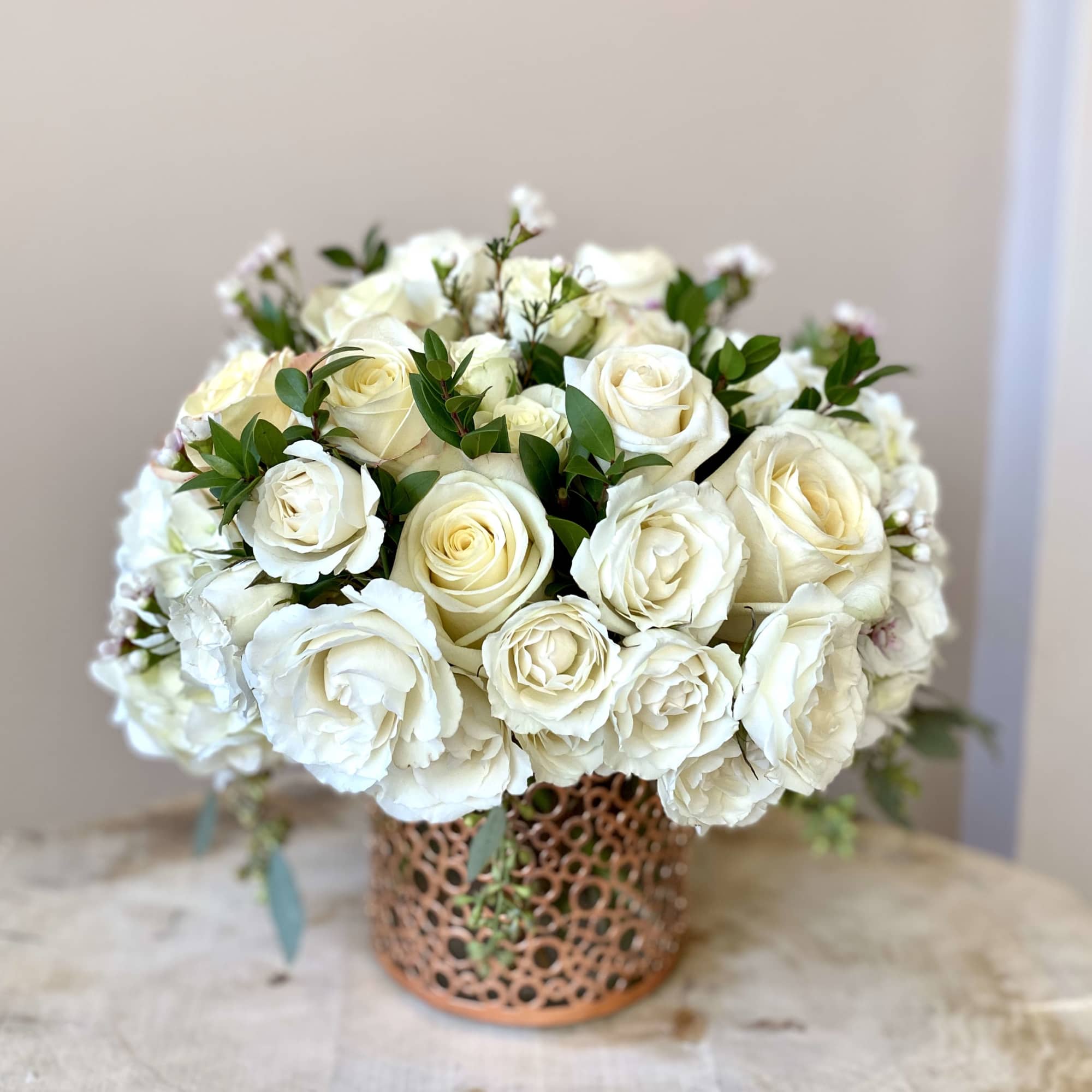 White rose bouquet in a decorative copper vase