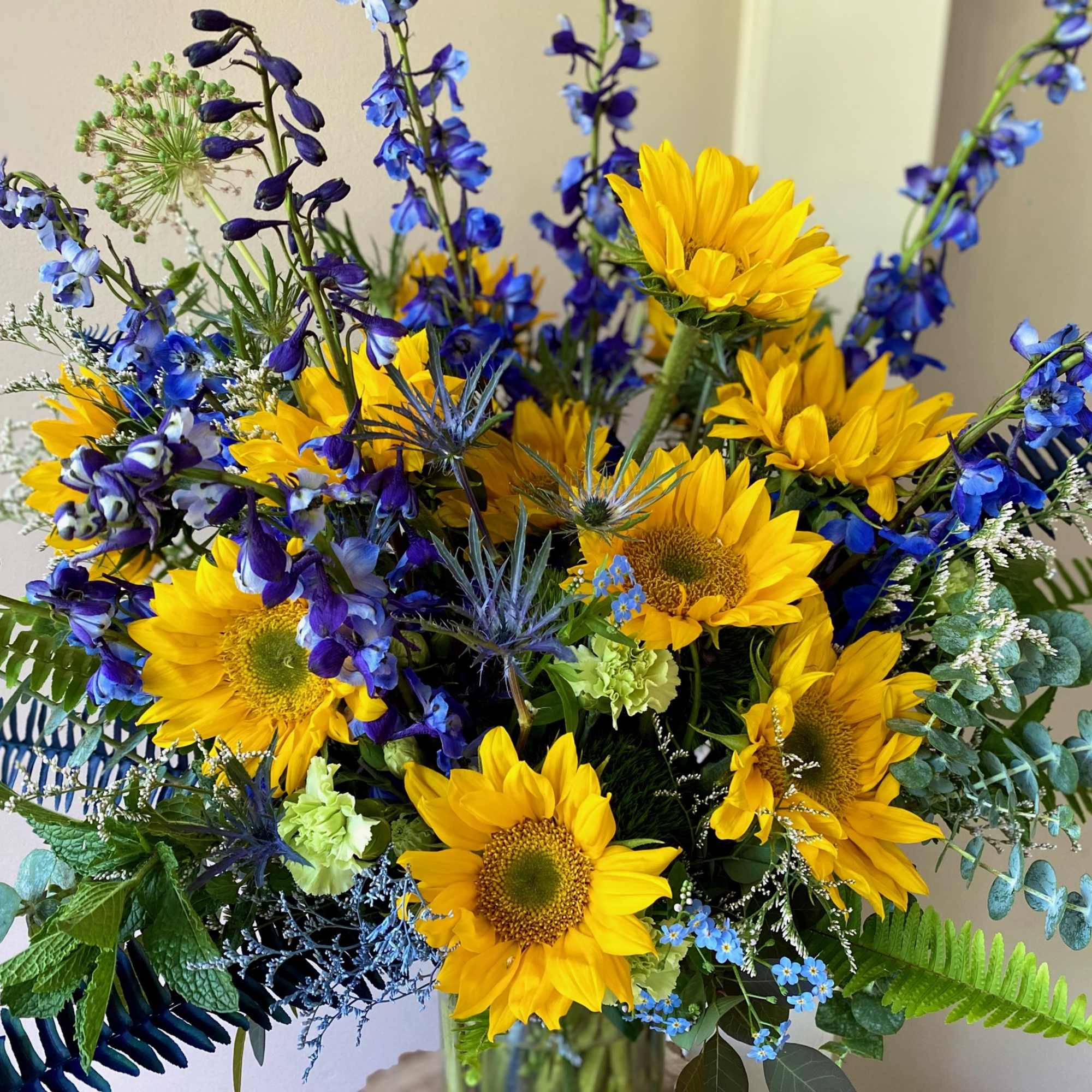 Bouquet of yellow sunflowers and blue flowers in a glass vase, photo 3 of 3