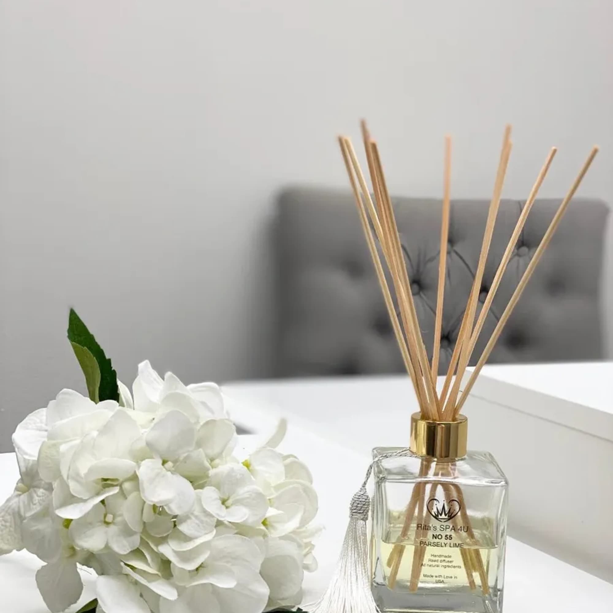 White hydrangea bouquet beside a reed diffuser bottle