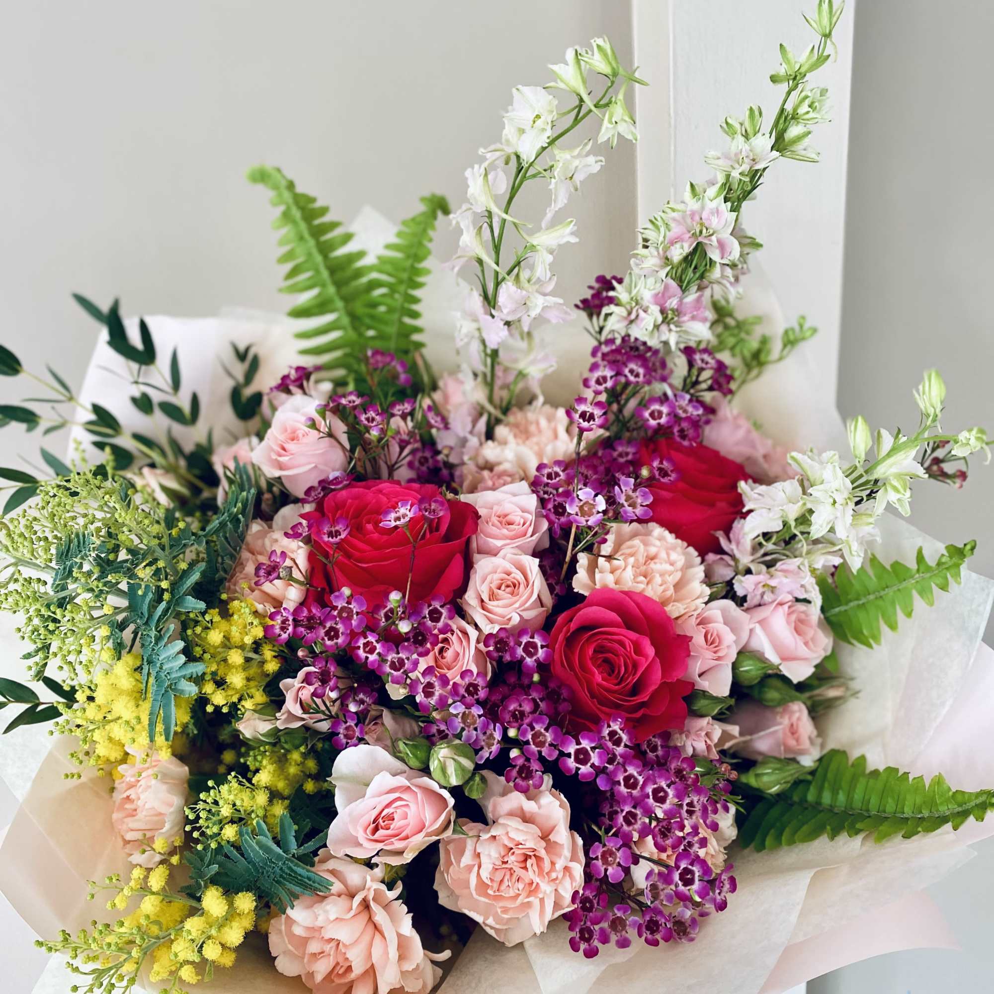 Bouquet of pink and red roses with purple filler flowers