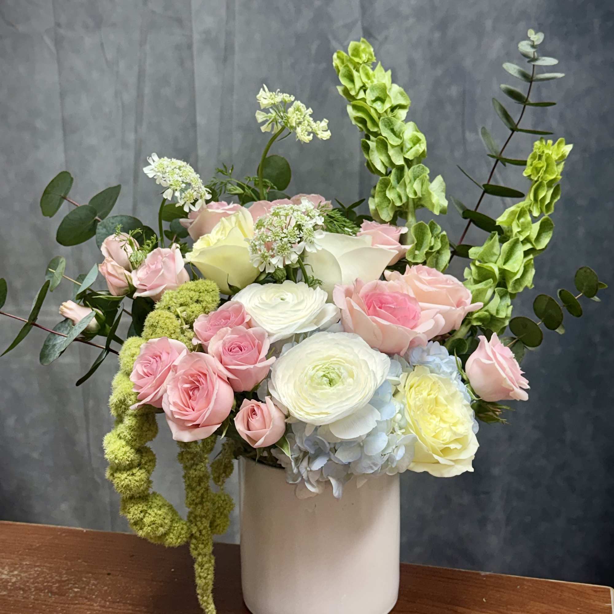Pink and white roses with ranunculus in a white vase, photo 2 of 2