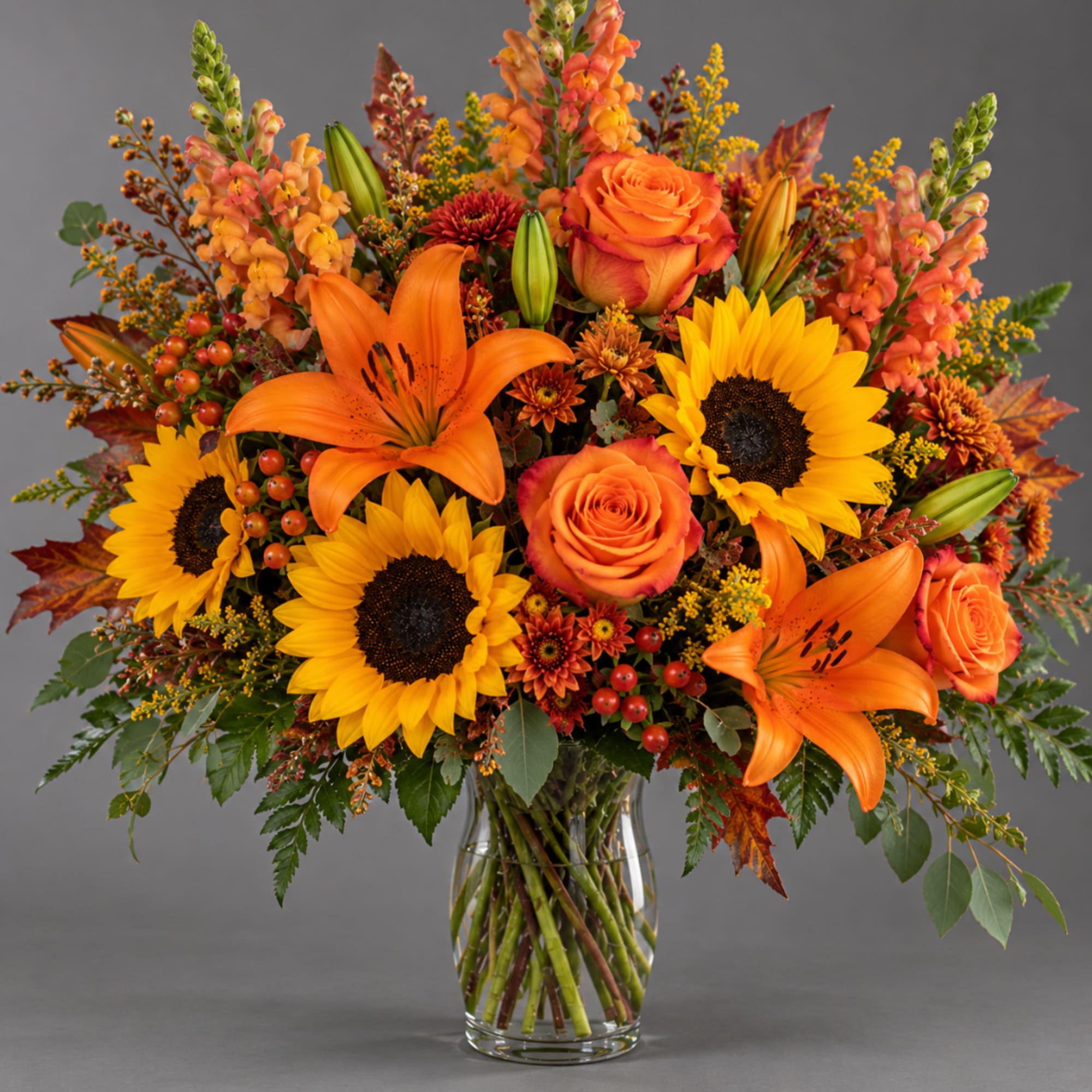 Orange lilies and sunflowers in a glass vase