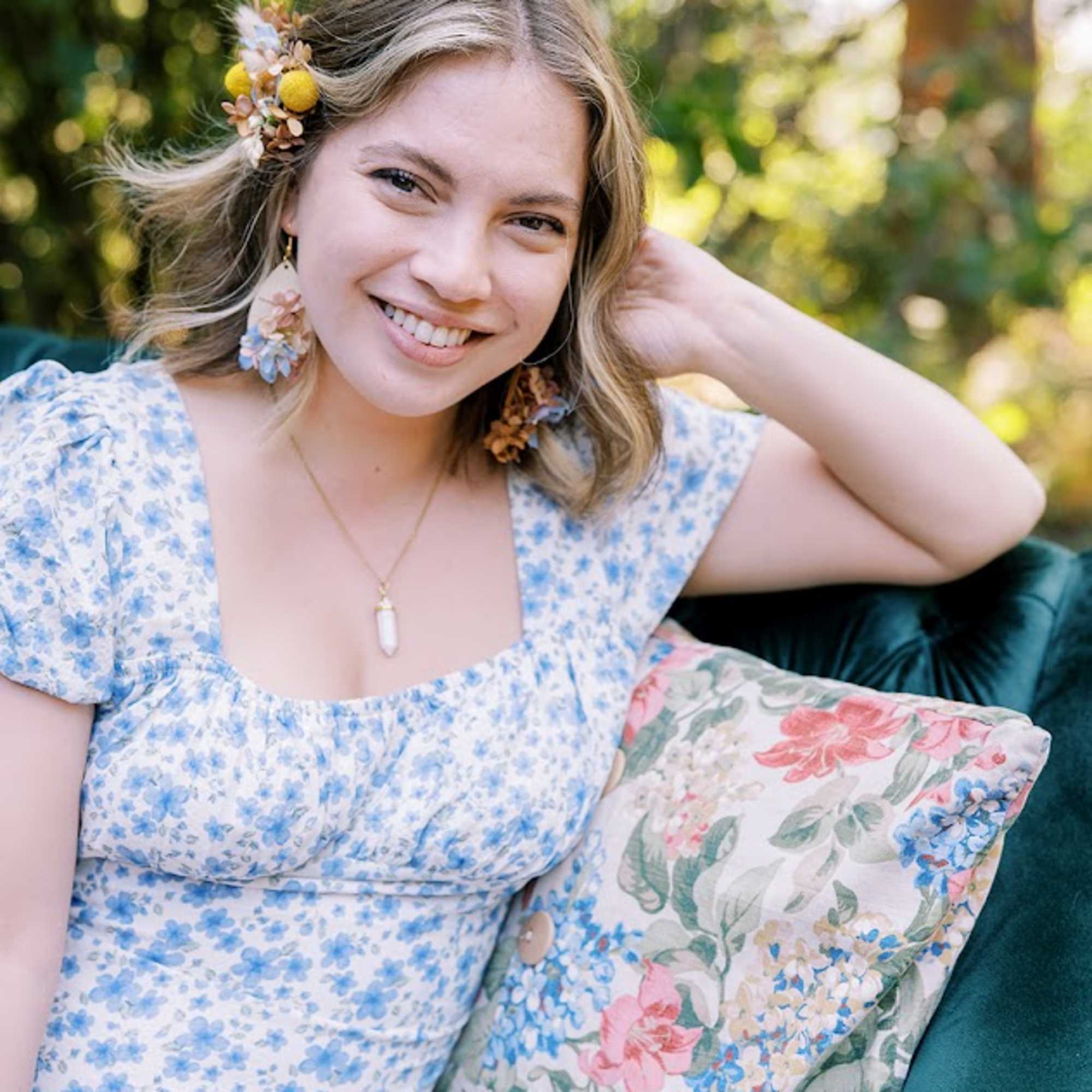 Woman wearing floral hair accessories and earrings outdoors