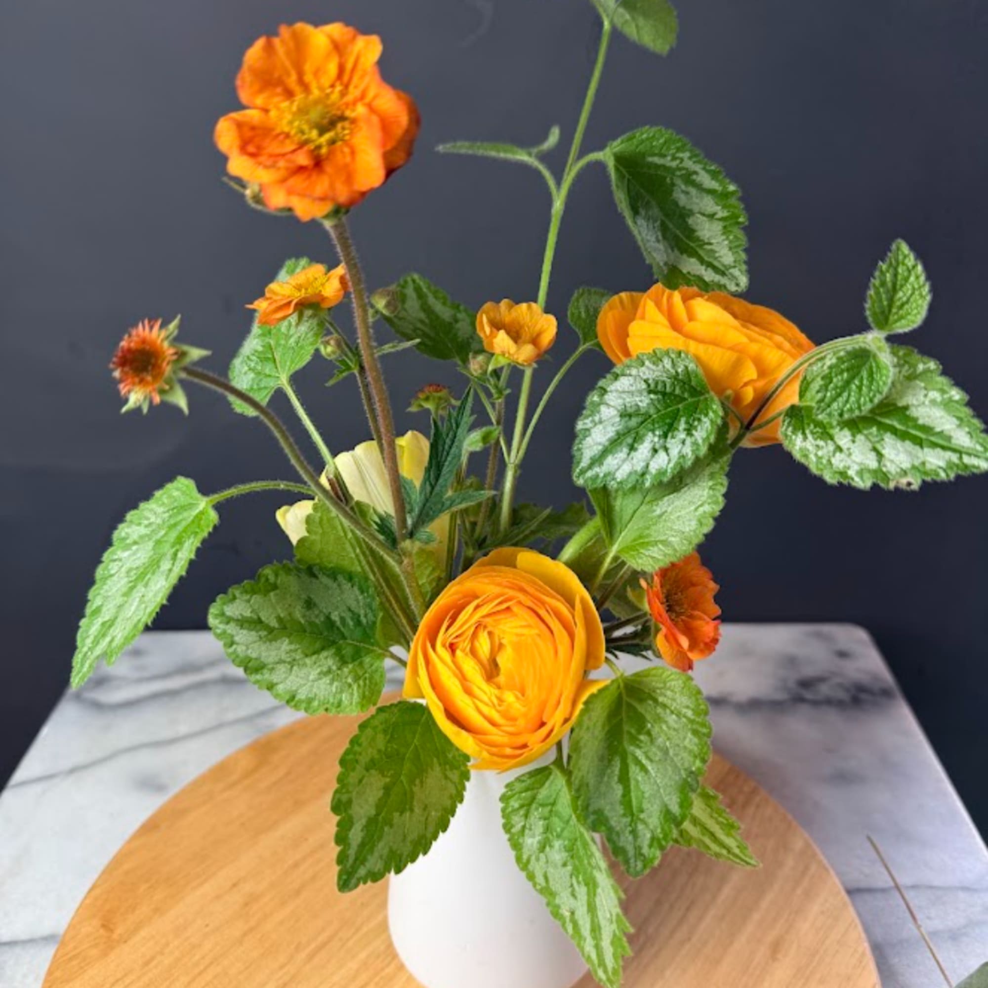 Orange flowers arranged in a white vase