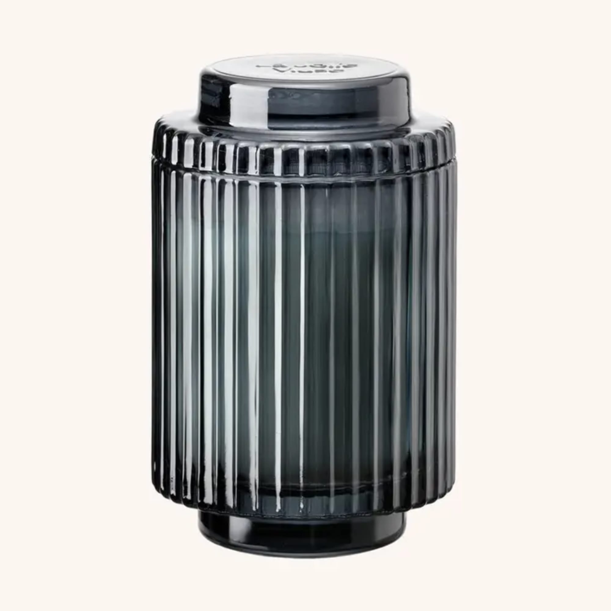 Black ribbed glass jar with a lid on a plain background