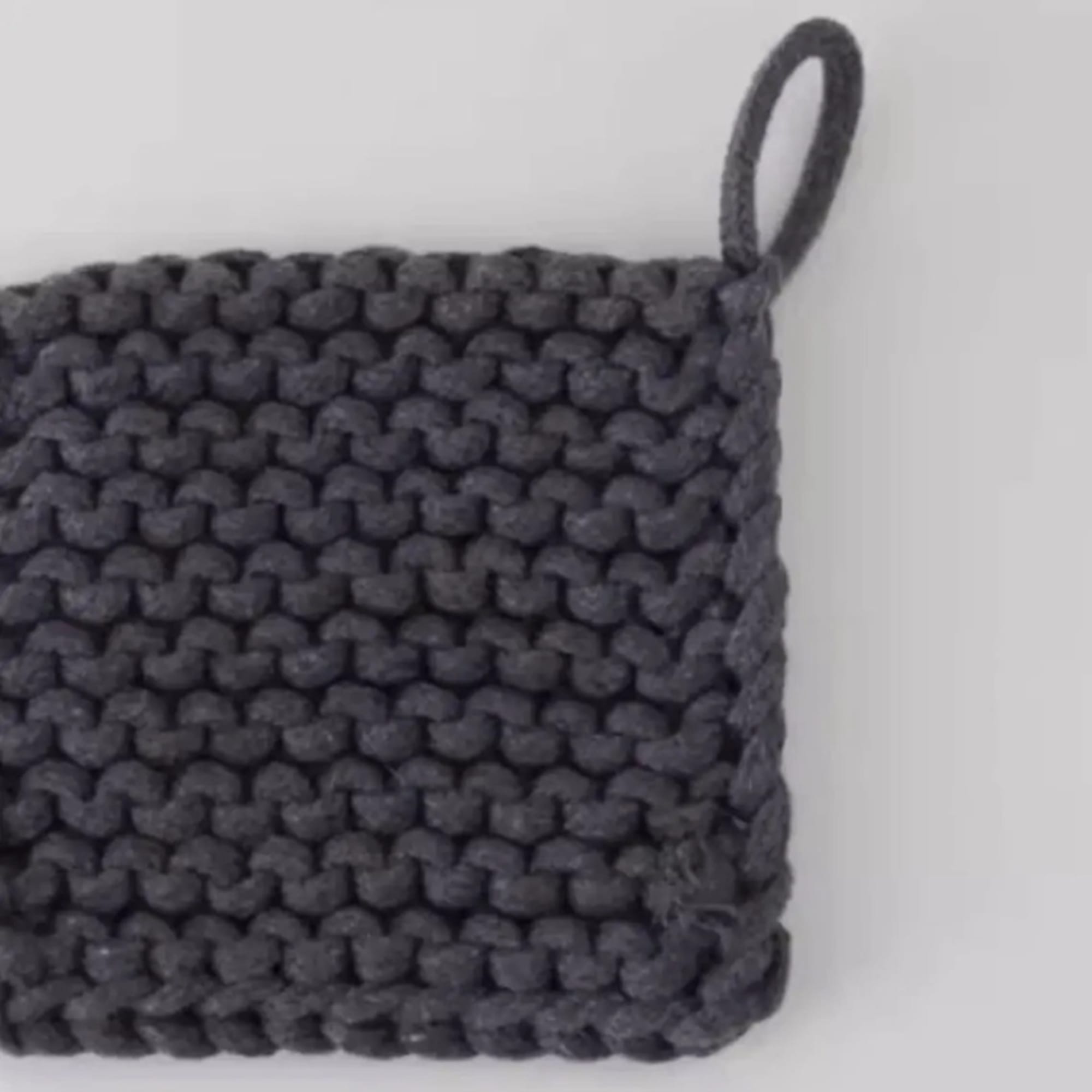 Dark knitted square pouch with a loop handle