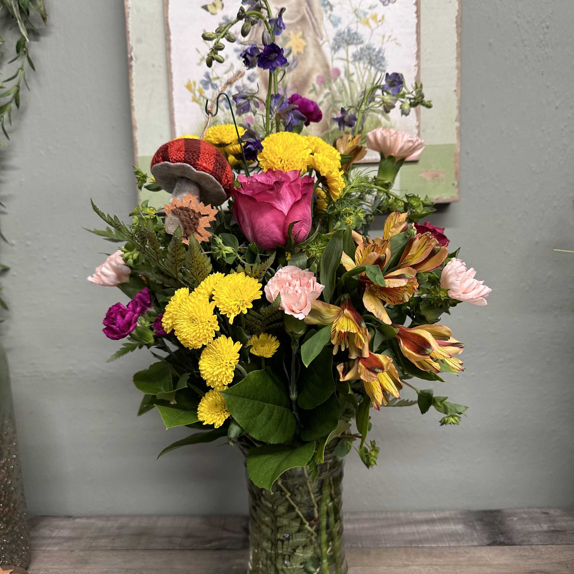 Mixed bouquet in a clear glass vase with pink, yellow, and purple flowers